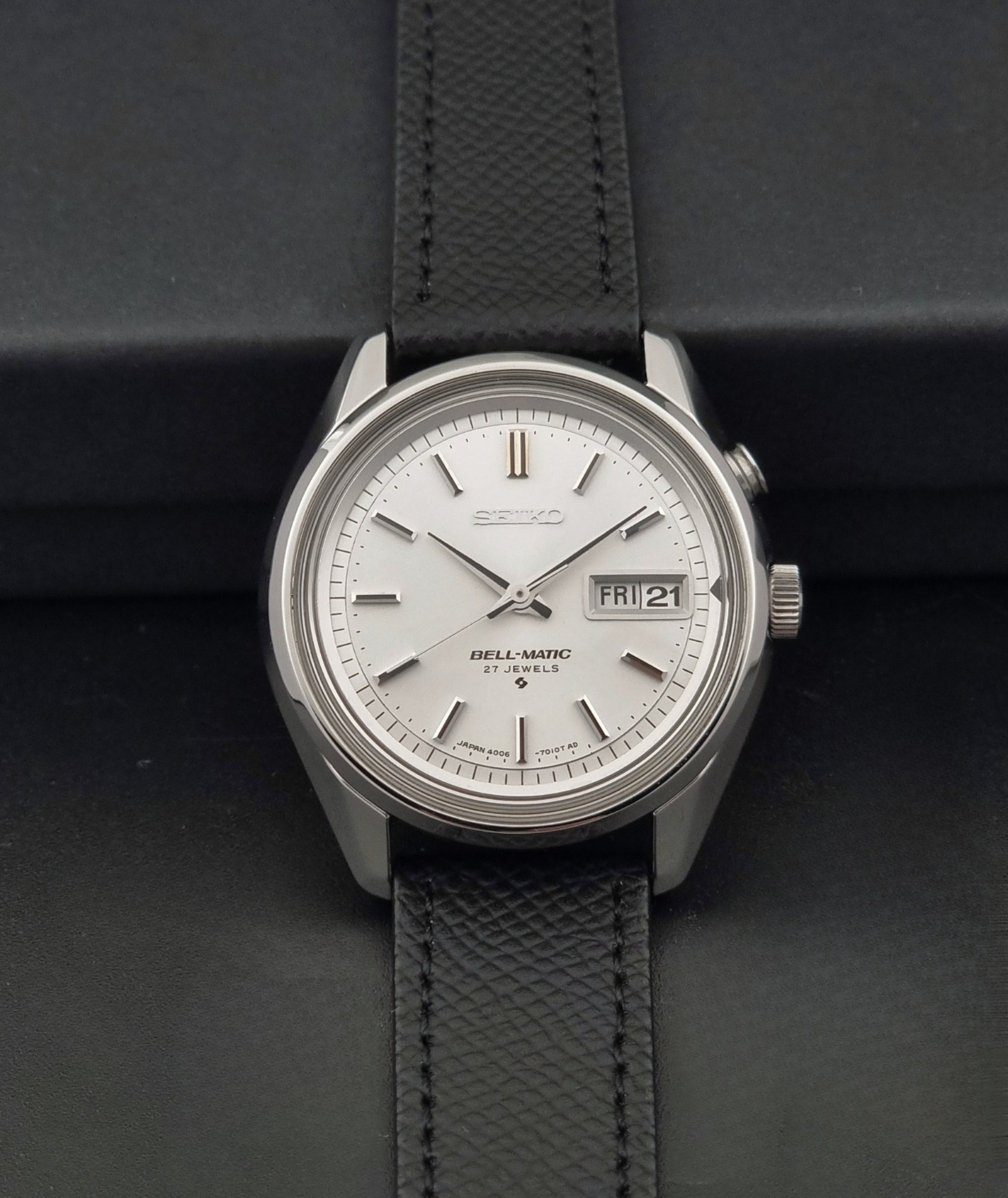 Vintage Seiko Alarm Wristwatch Bell-Matic 4006-7011 with a black strap on a dark background dial view