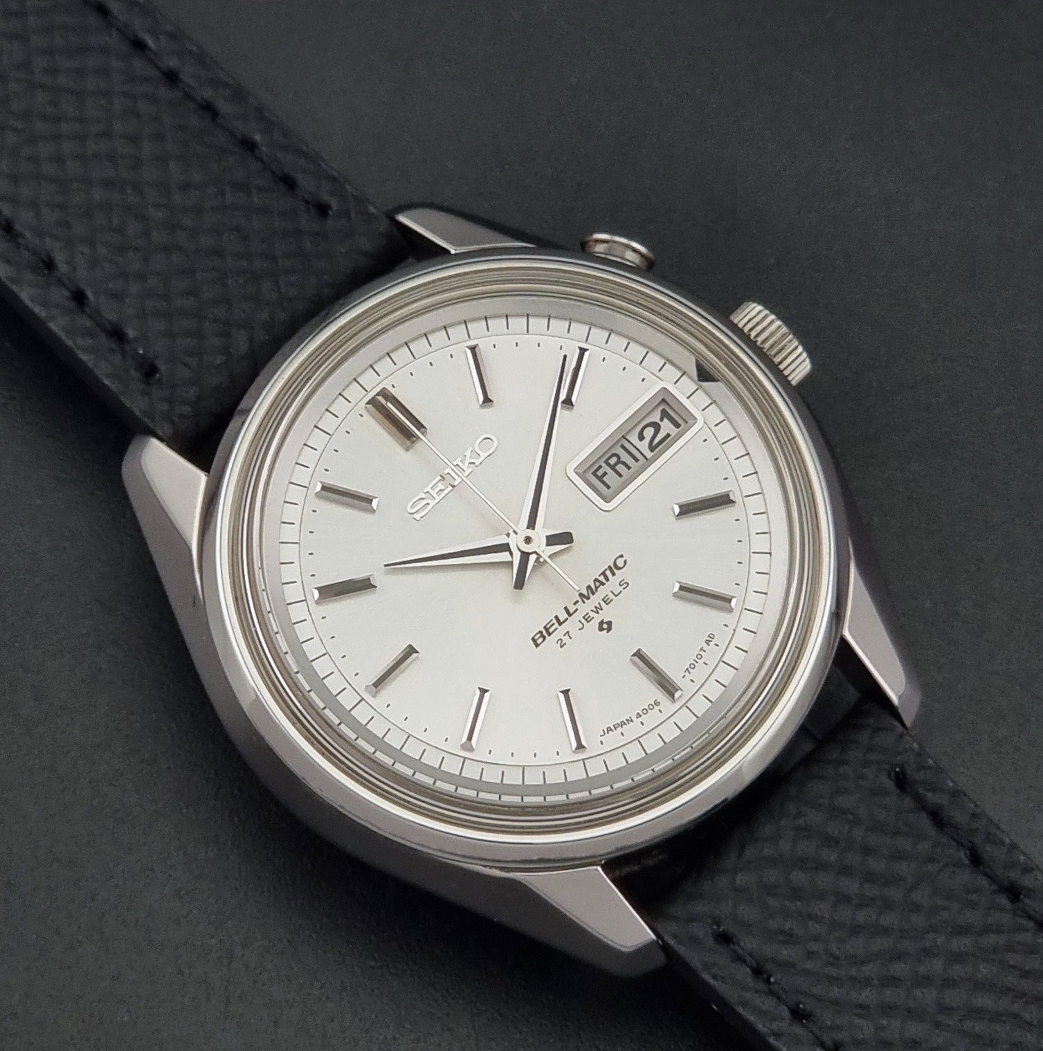 Vintage Seiko Alarm Wristwatch Bell-Matic 4006-7011 with a black strap on a dark background close up dial view
