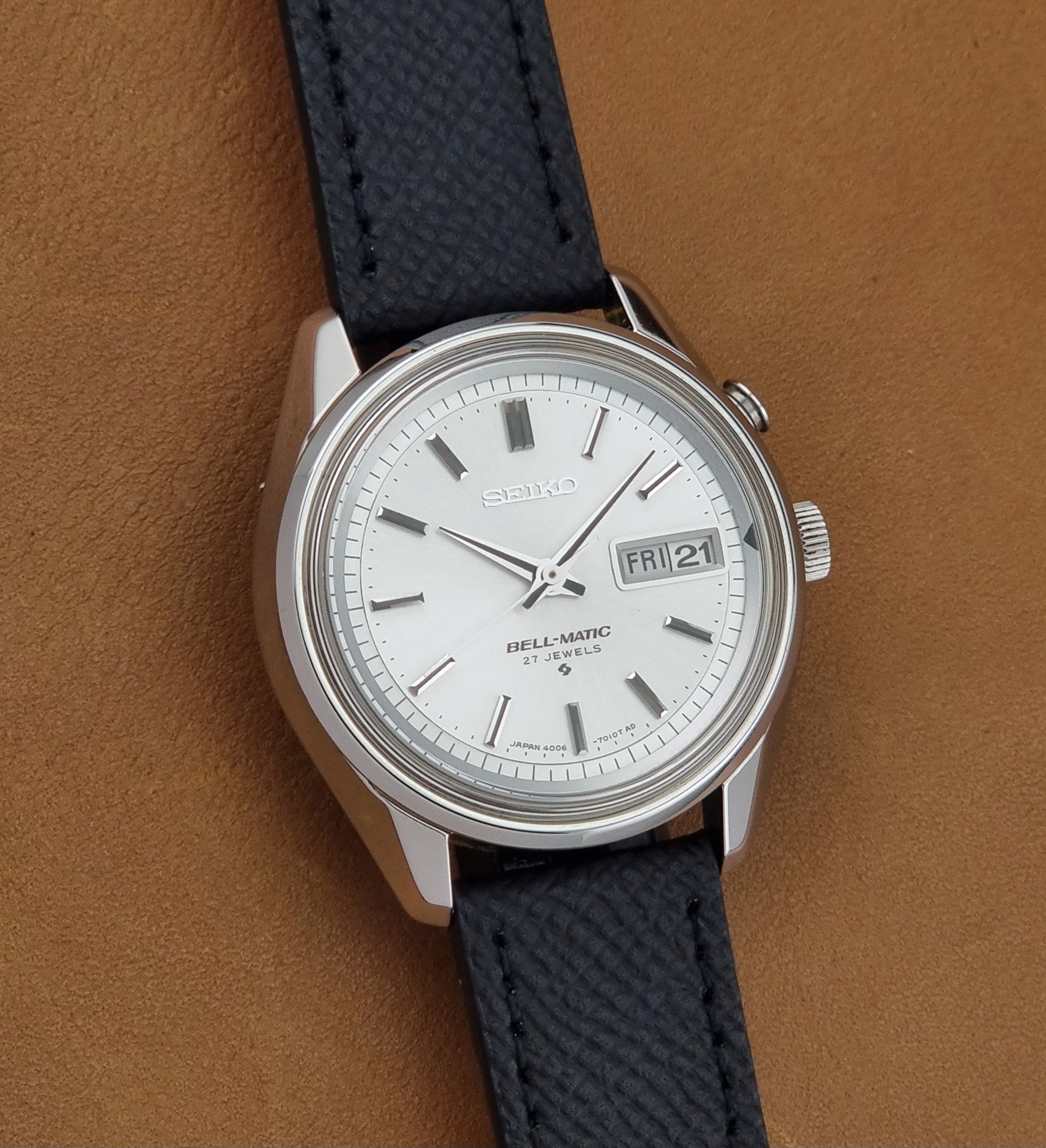 Vintage Seiko Alarm Wristwatch Bell-Matic 4006-7011 with a black strap on a brown background front