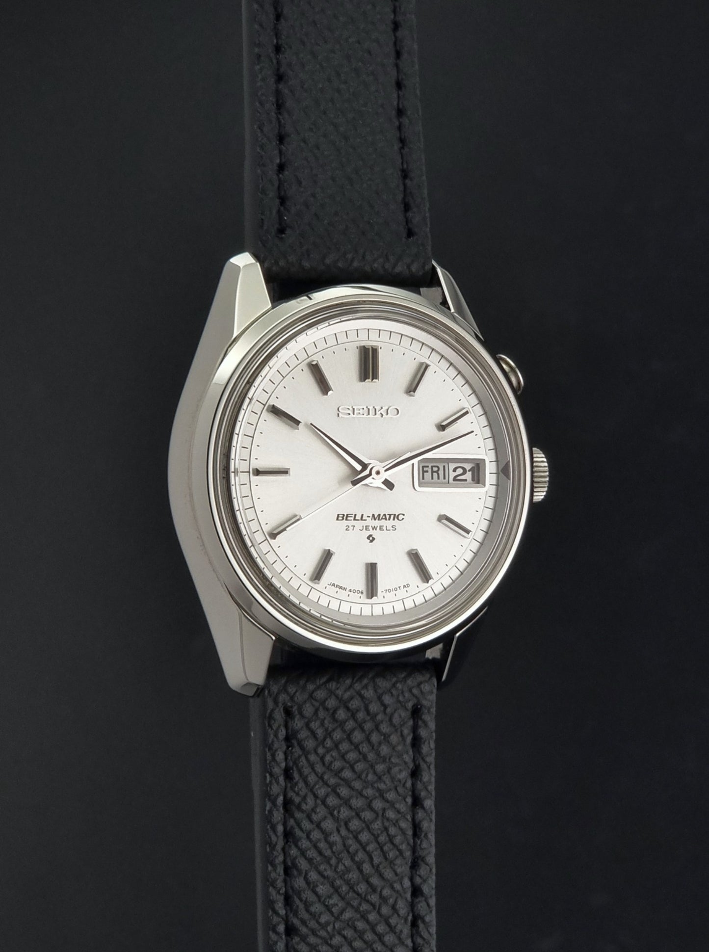 Vintage Seiko Alarm Wristwatch Bell-Matic 4006-7011 with a black strap on a dark background side profile view