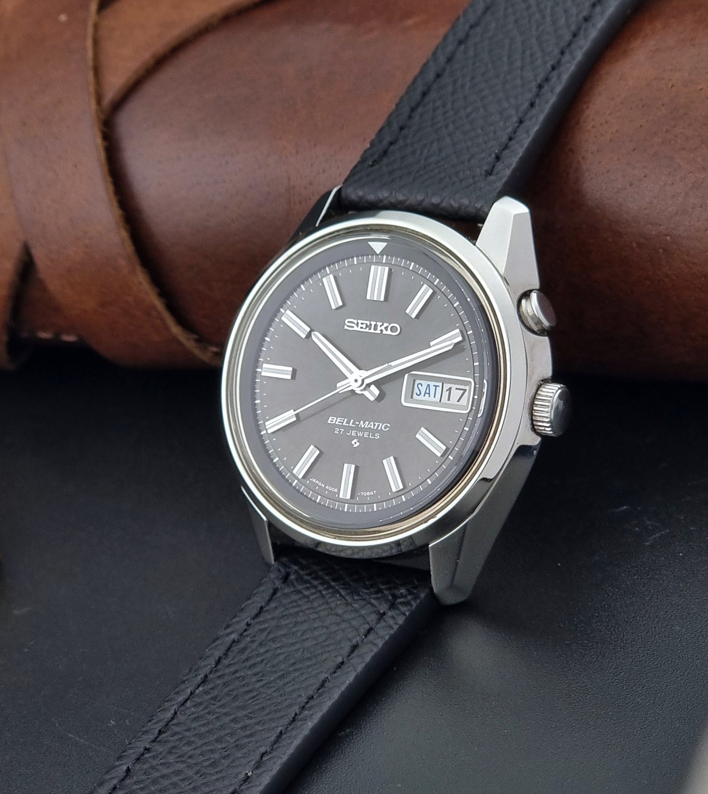 Vintage Seiko Alarm Watch Bell-Matic 4006-7012 with a grey dial and black leather strap on a dark surface crown view