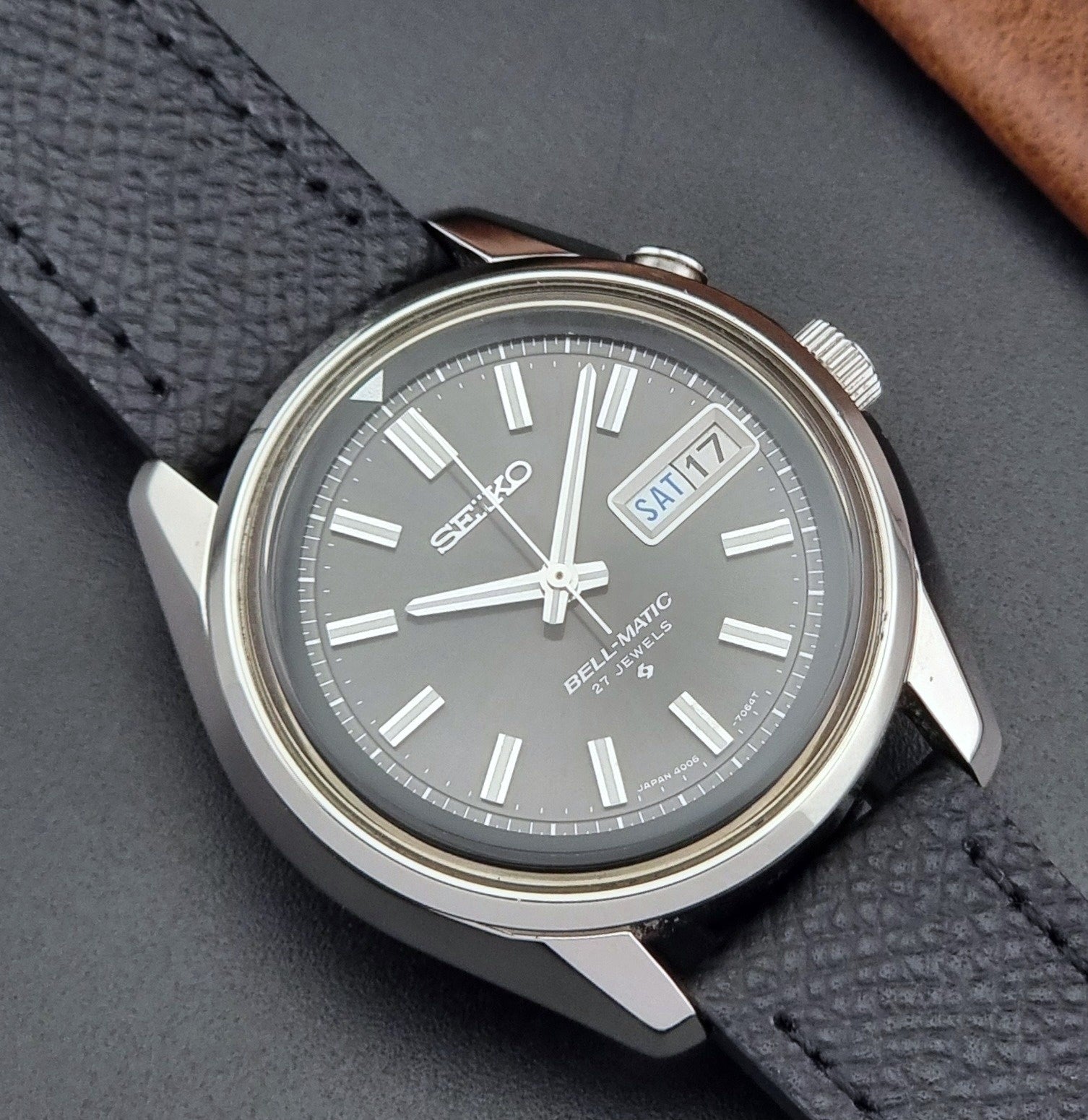 Vintage Seiko Alarm Watch Bell-Matic 4006-7012 with a grey dial and black leather strap on a dark surface close up dial view