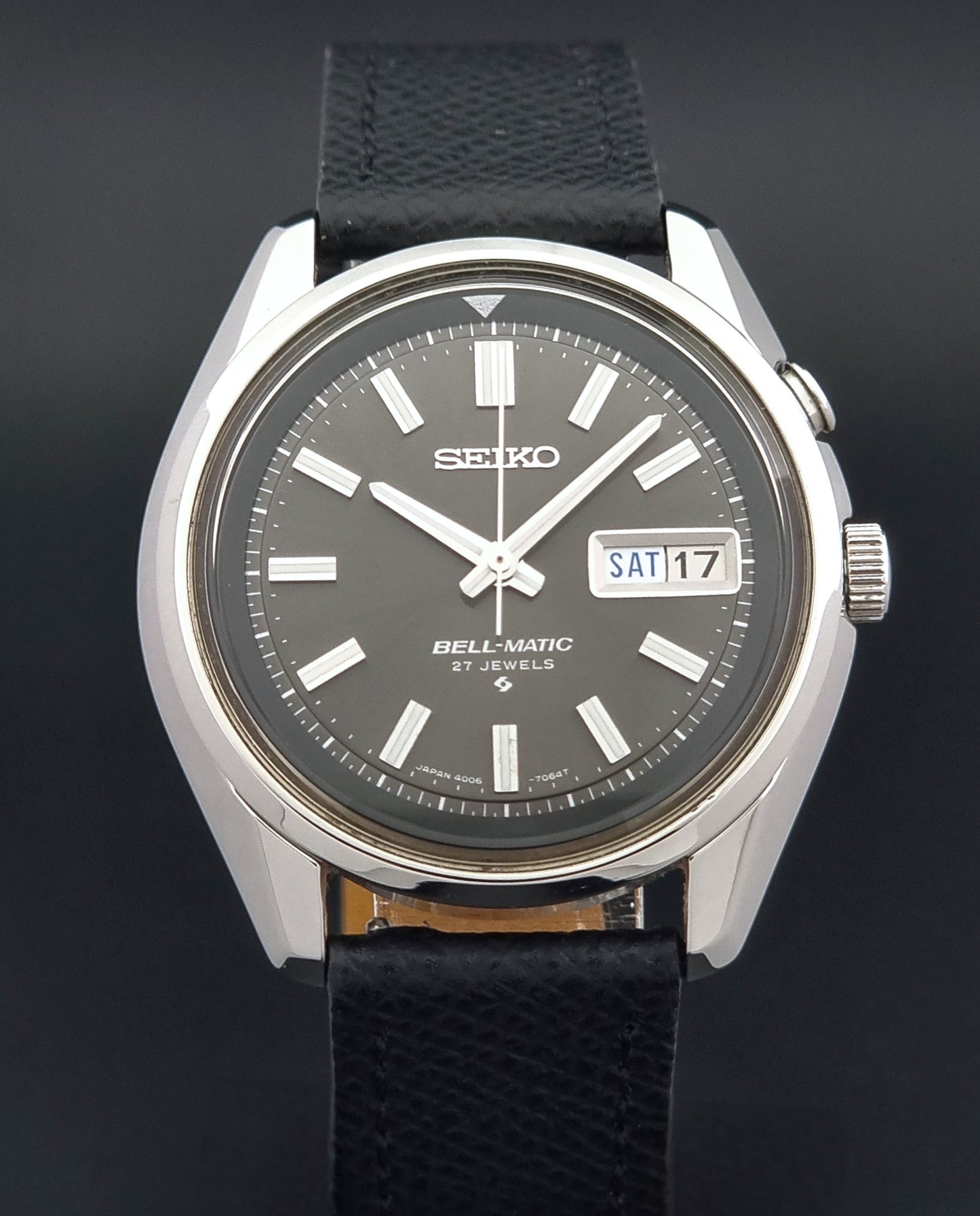 Vintage Seiko Alarm Watch Bell-Matic 4006-7012 with a grey dial and black leather strap on a dark surface close dial view