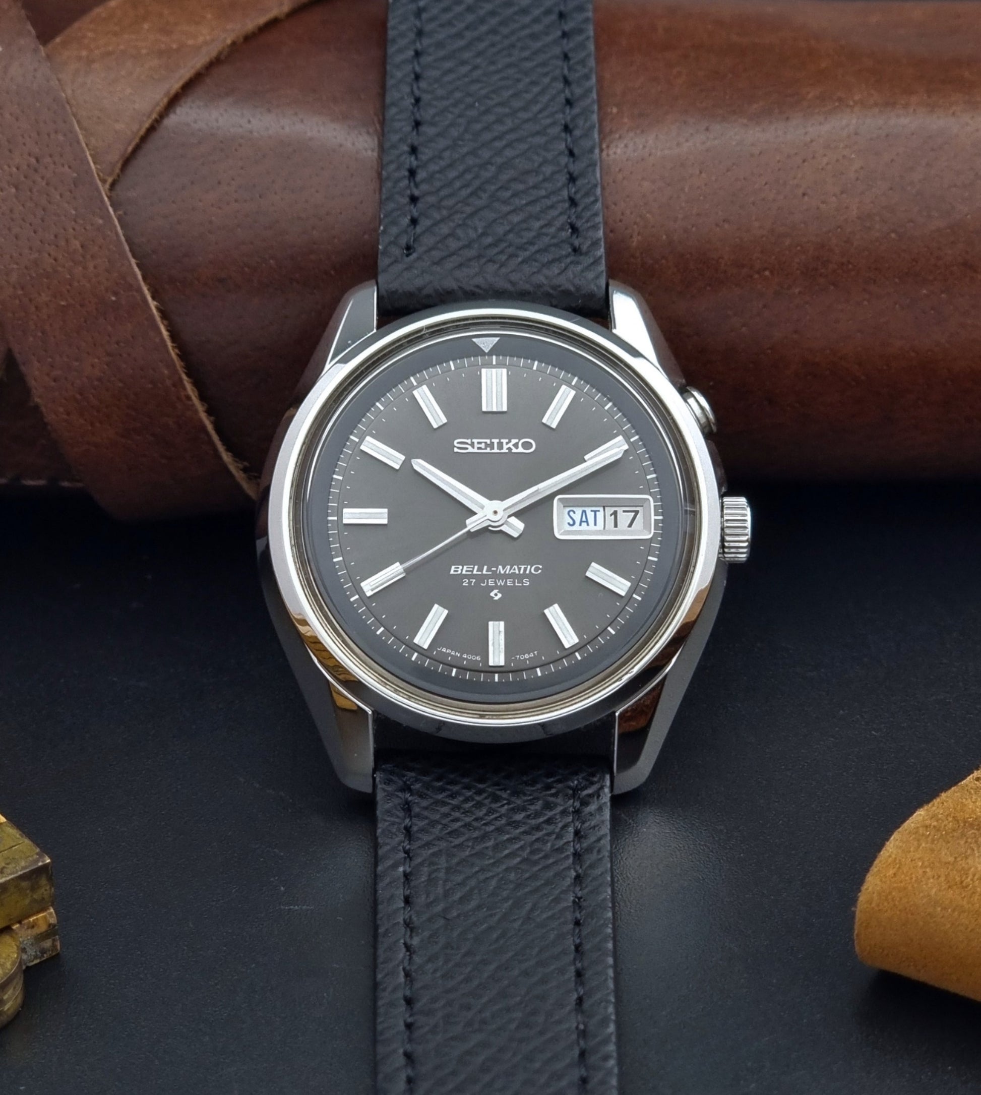 Vintage Seiko Alarm Watch Bell-Matic 4006-7012 with a grey dial and black leather strap on a dark surface dial view