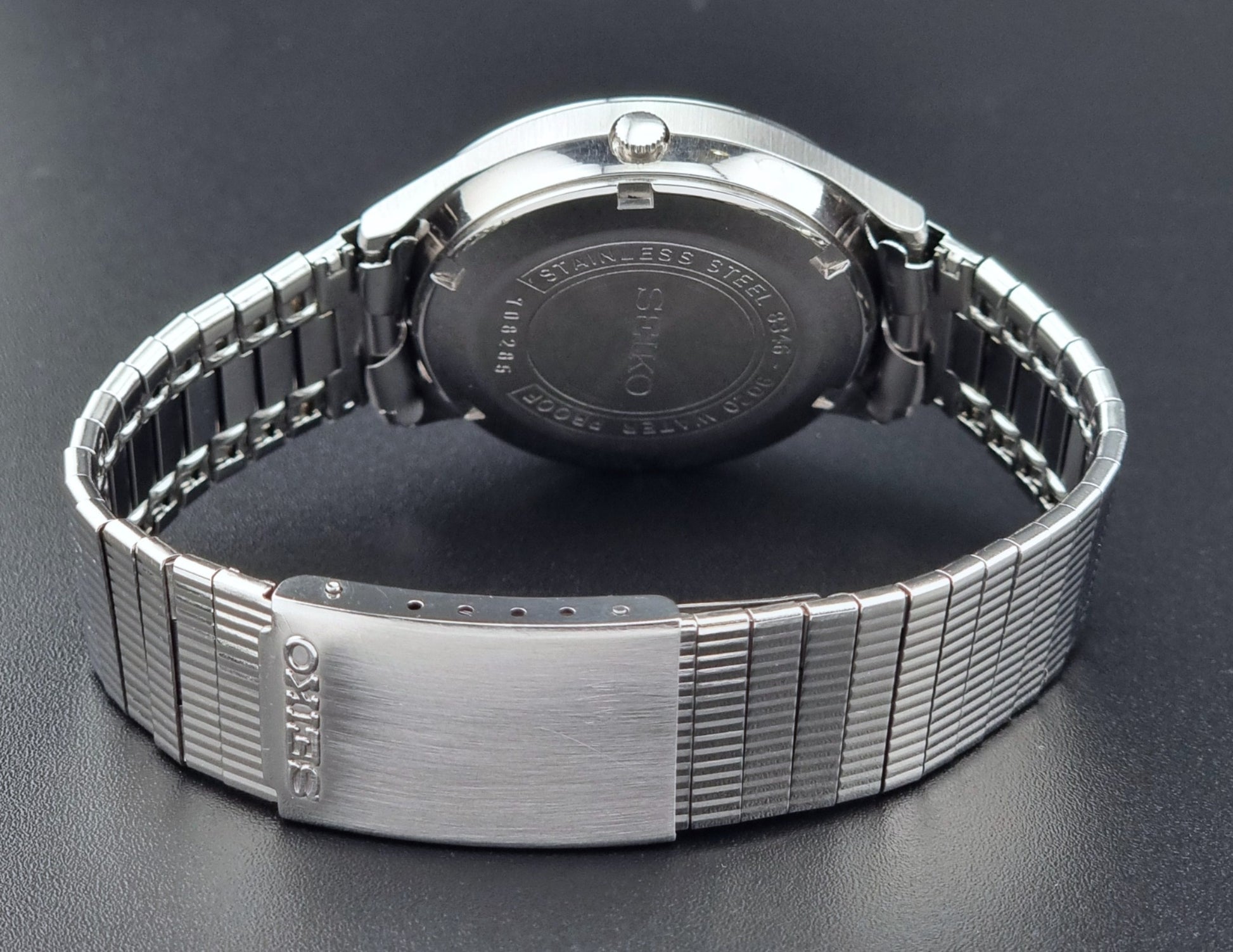 The back of a Seiko watch on a dark background