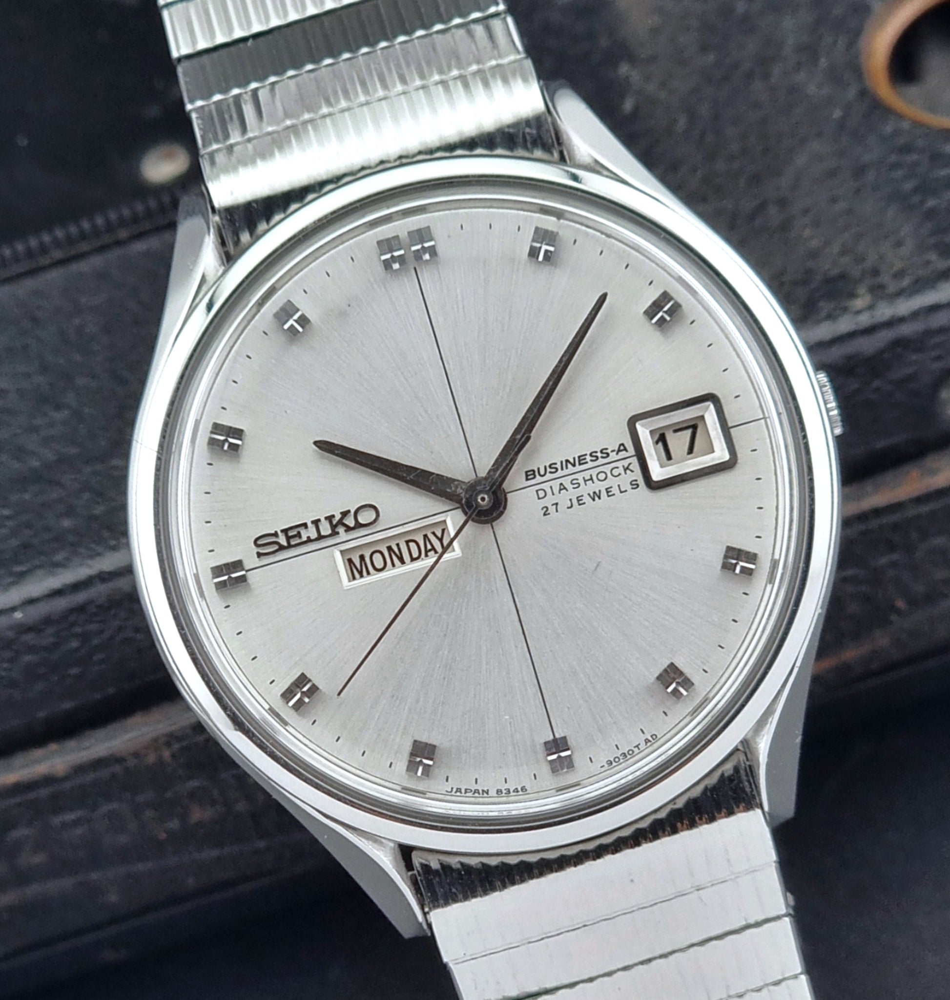 Silver Seiko watch with a dark background