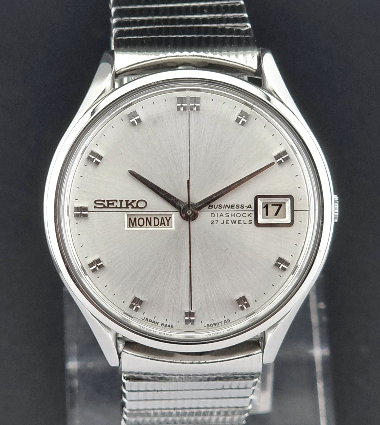 Silver Seiko wristwatch with a dark background