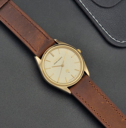 Vintage Seiko Grand Quartz watch 9940-8010 with brown leather strap on a dark textured background dial