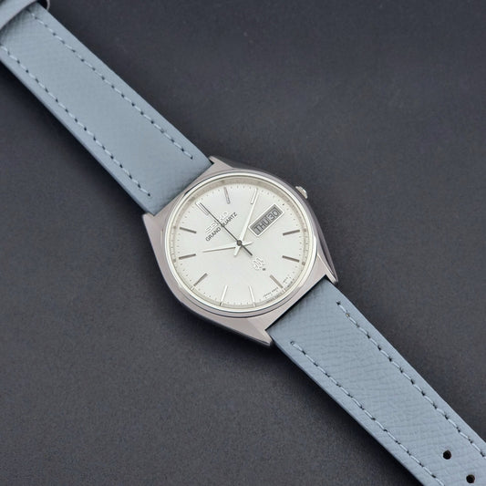 Vintage Seiko Grand Quartz 9943-8010 with a light grey strap on a dark background dial