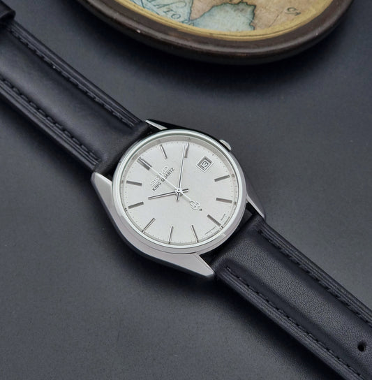 Vintage King Quartz watch 4822-8000 with black strap and silver case on a dark surface dial