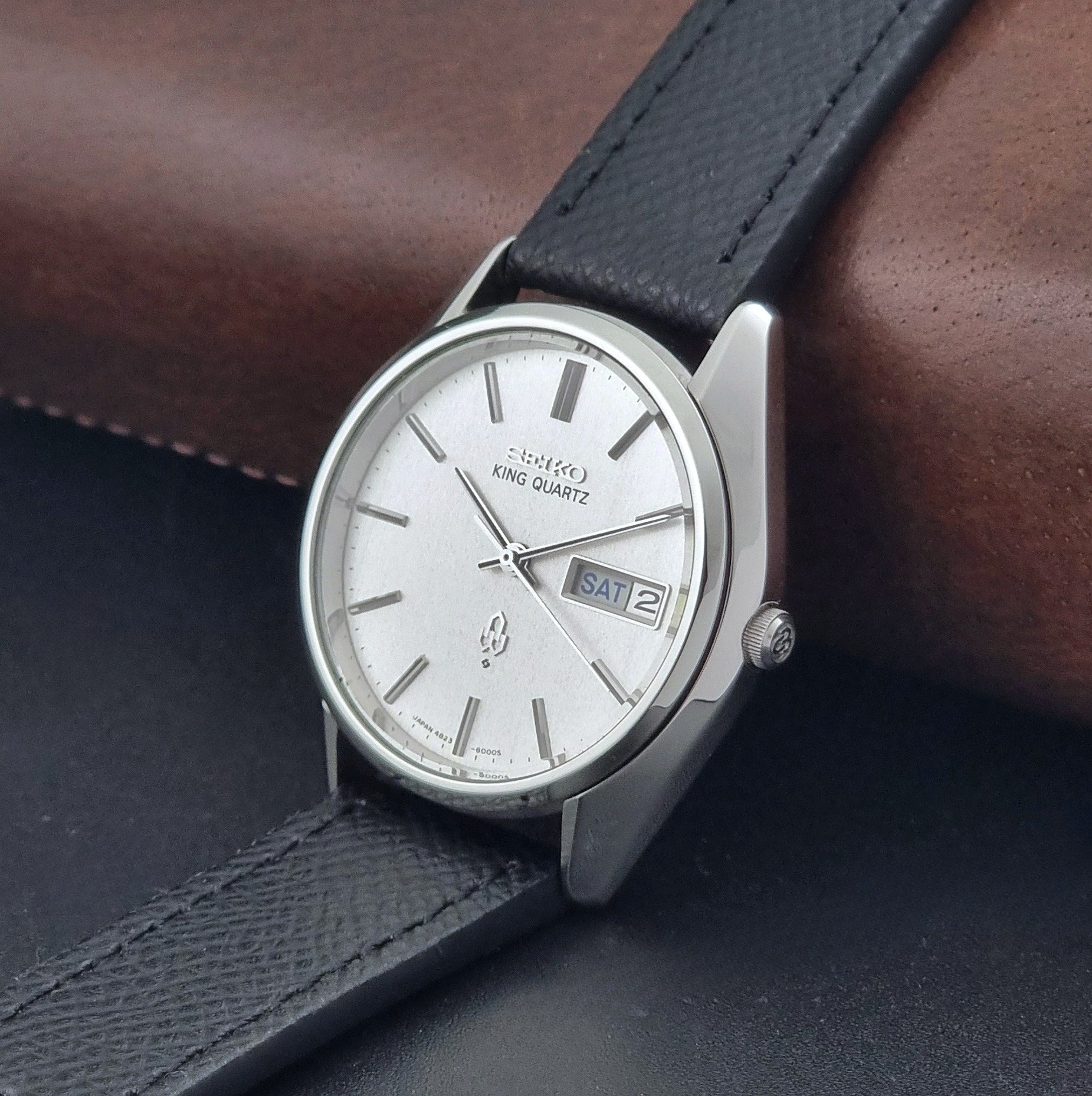 Vintage Seiko King Quartz watch 4823-8000  with black leather strap on a dark background crown view
