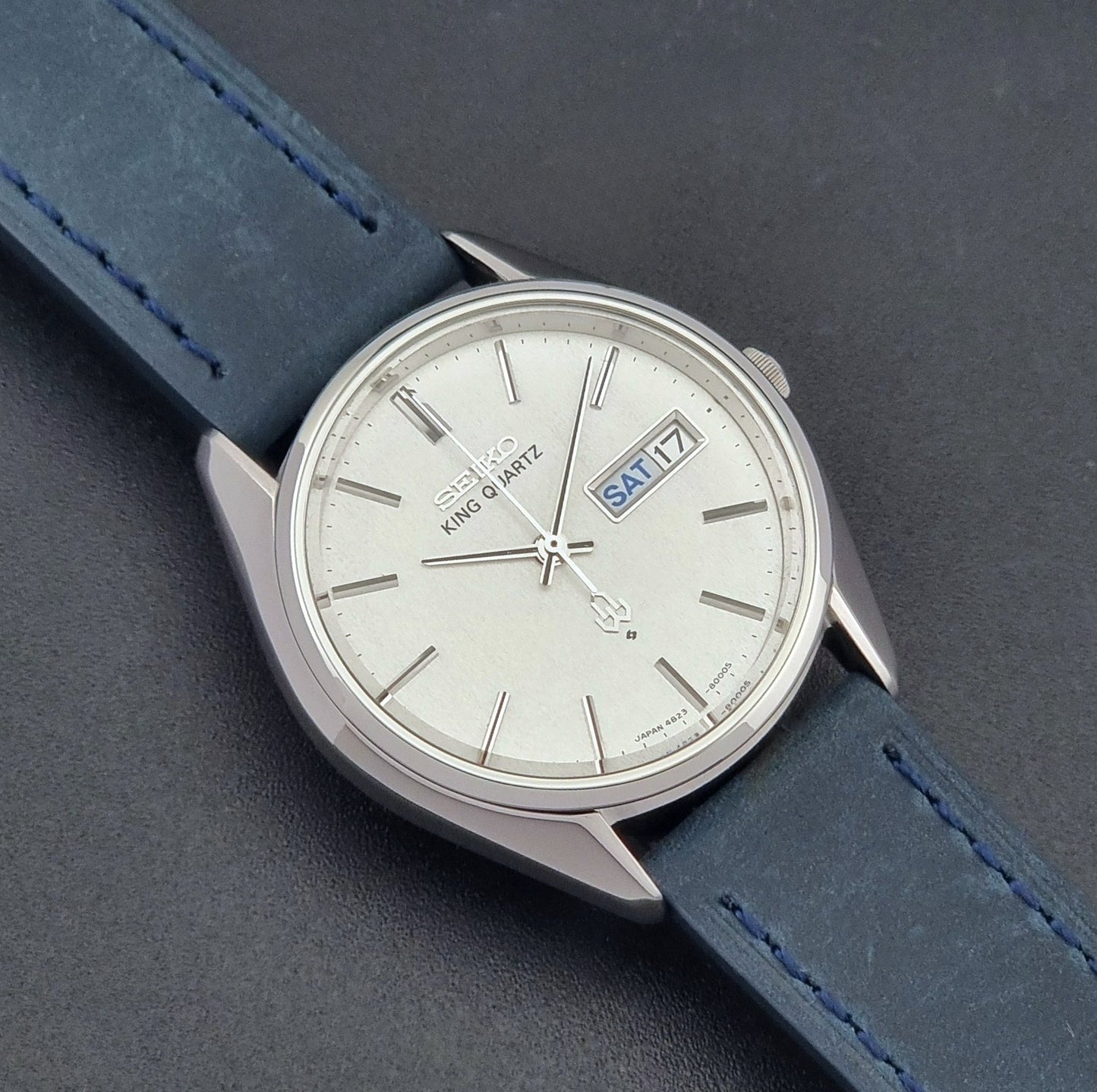 Vintage Seiko King Quartz 4823-8000-G with a blue leather strap on a dark background close up dial view