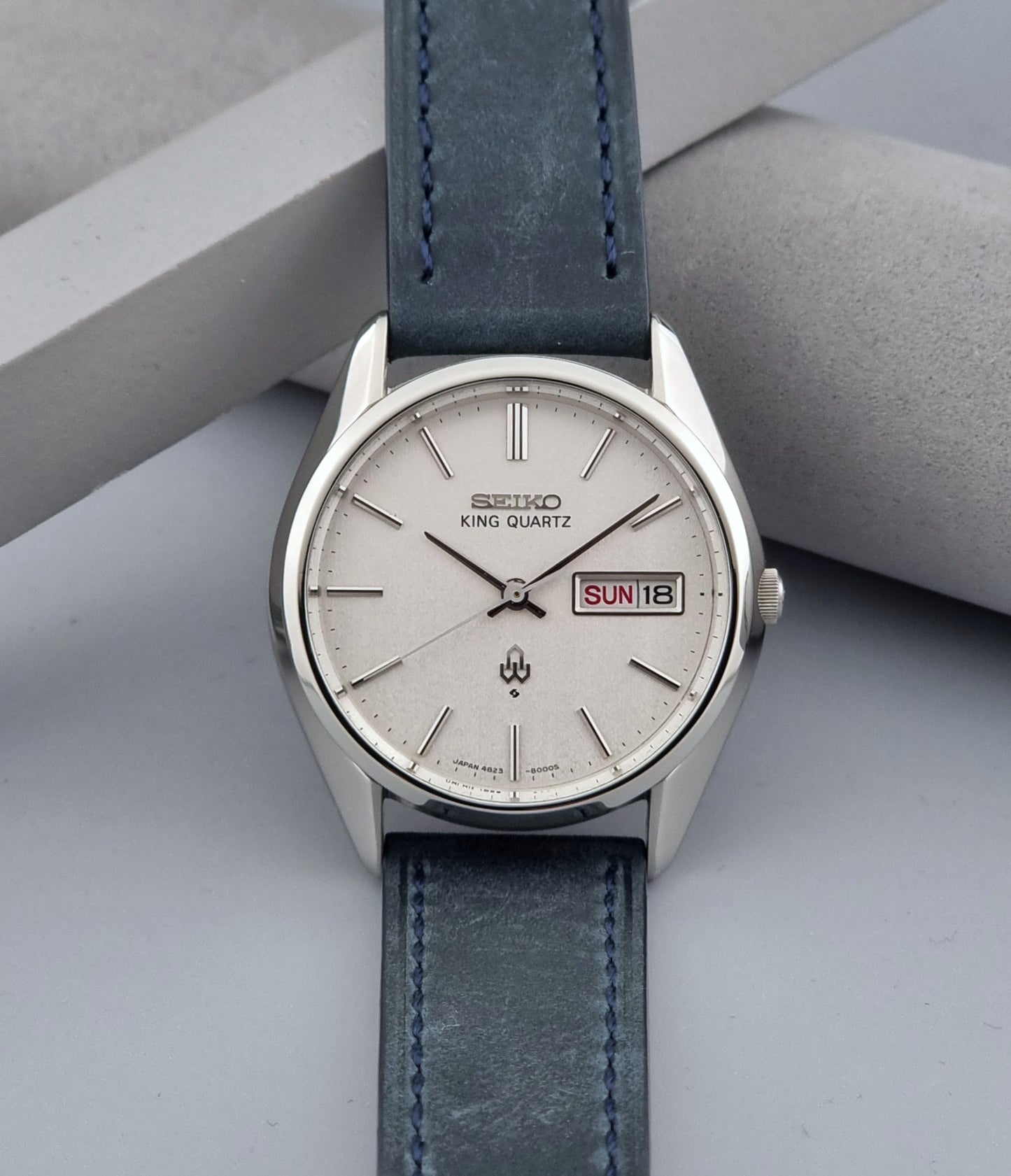 Vintage Seiko King Quartz 4823-8000-G with a blue leather strap on a dark background dial view