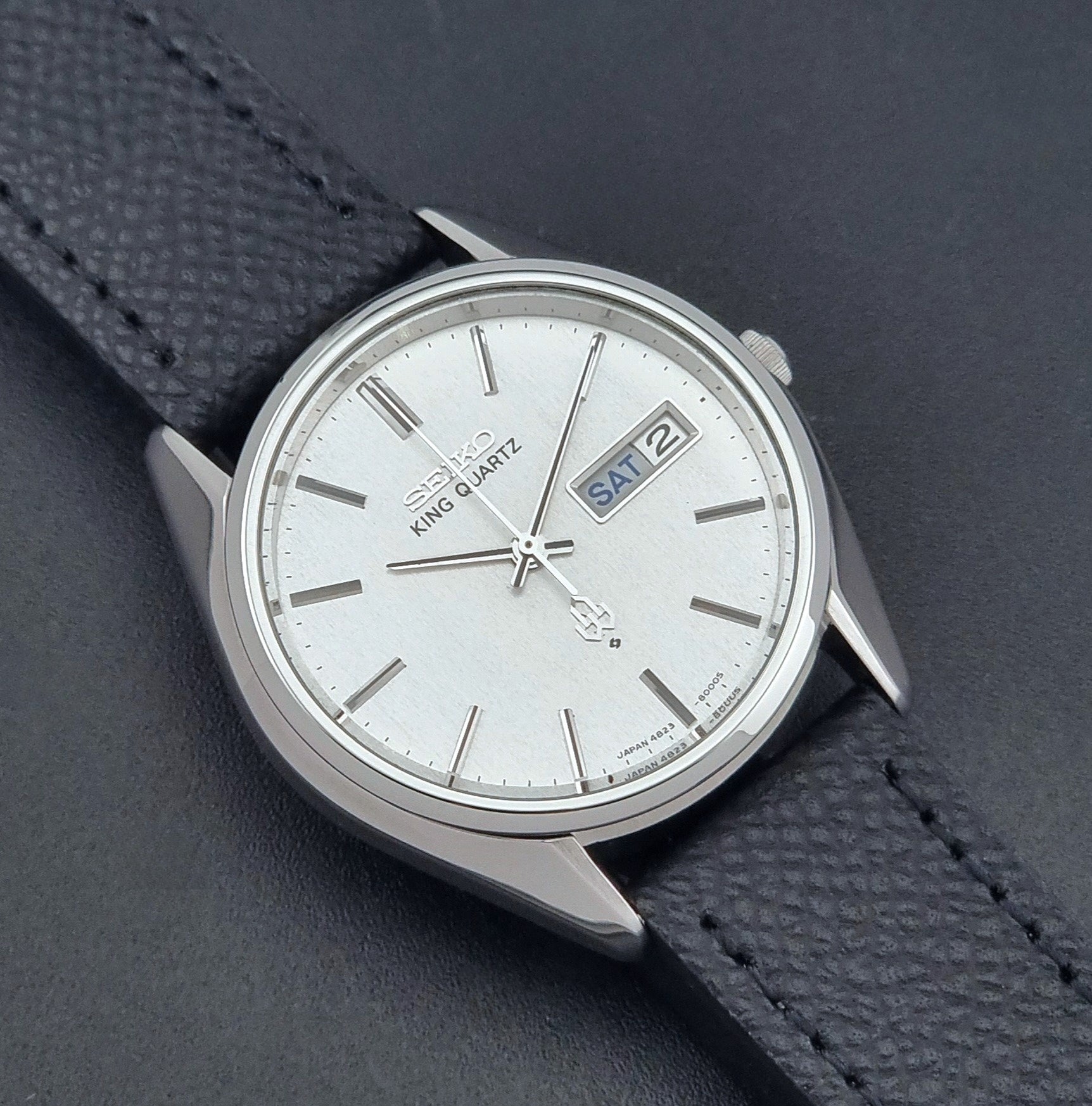 Vintage Seiko King Quartz watch 4823-8000  with black leather strap on a dark background close up dial view