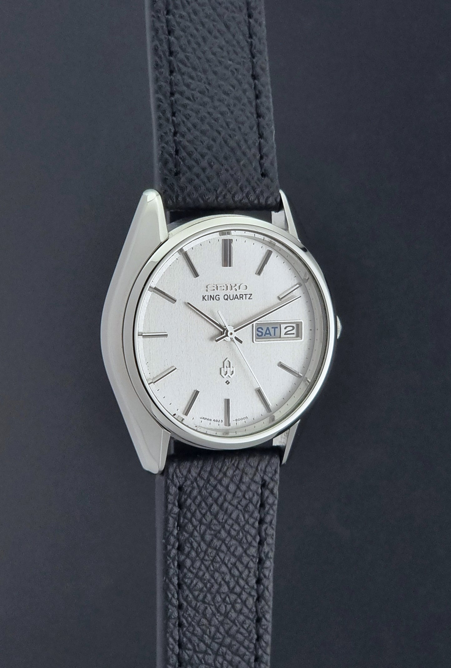 Vintage Seiko King Quartz watch 4823-8000  with black leather strap on a dark background side profile view