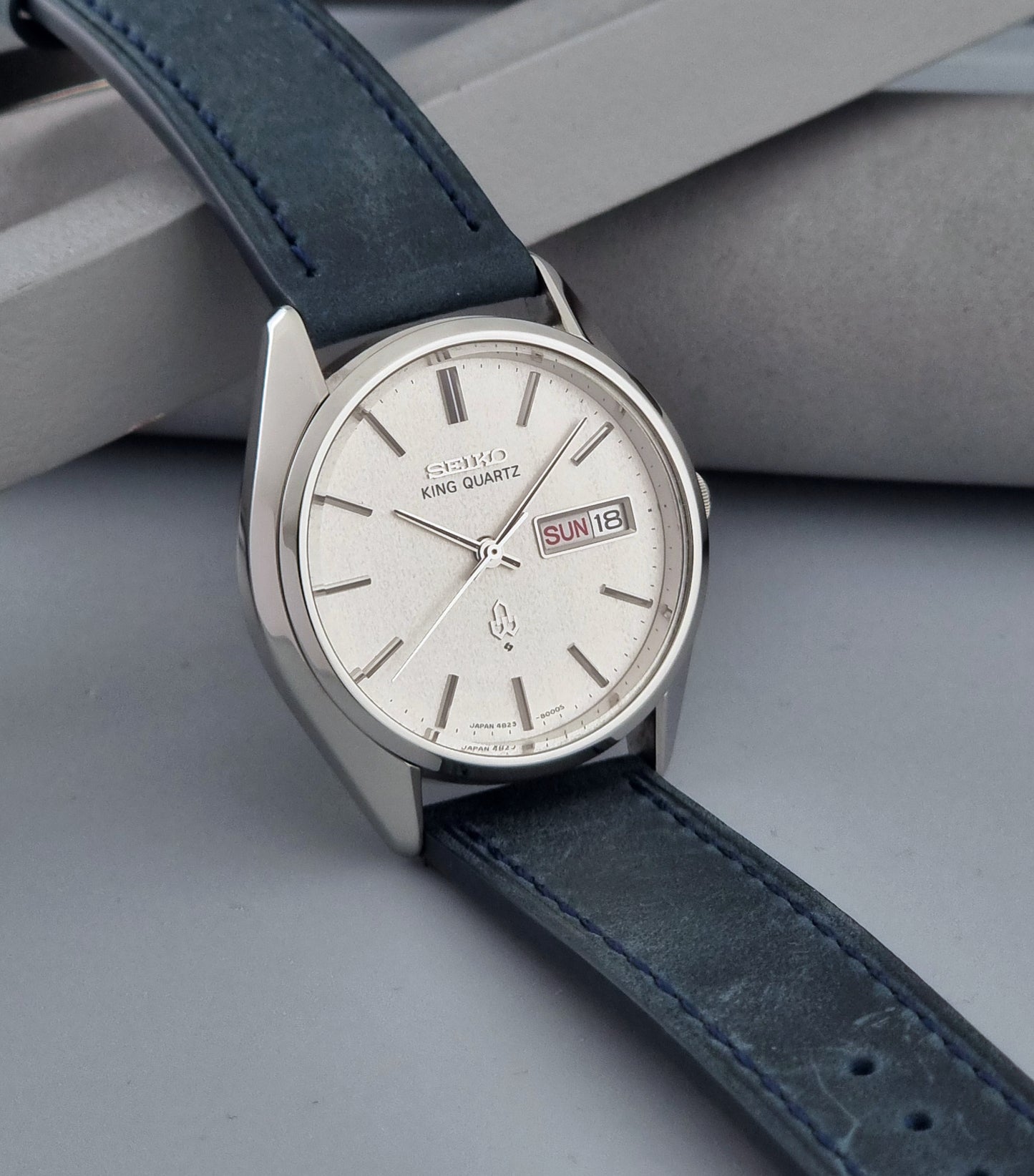 Vintage Seiko King Quartz 4823-8000-G with a blue leather strap on a dark background side view