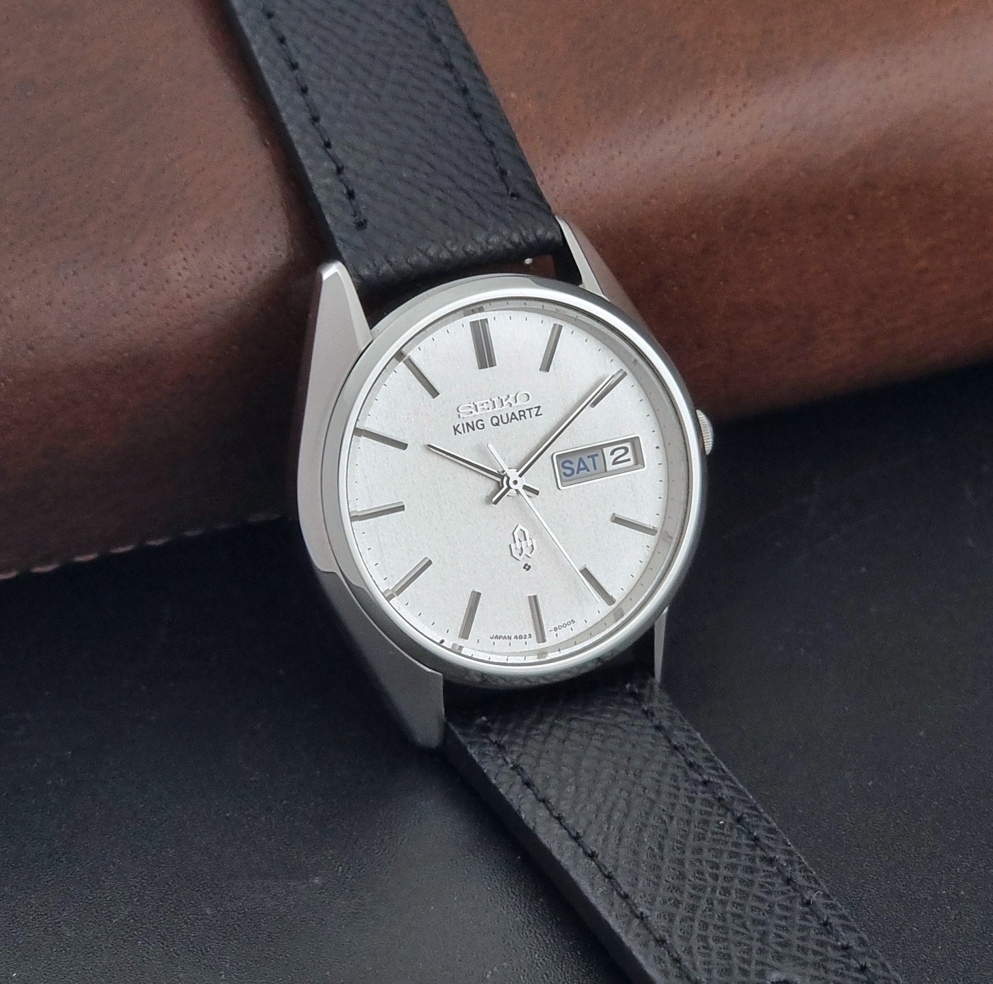 Vintage Seiko King Quartz watch 4823-8000  with black leather strap on a dark background side view