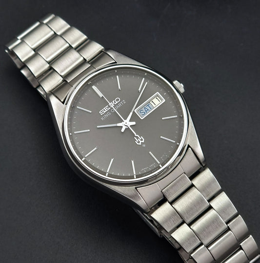 Vintage Seiko King Quartz watch 4823-8110 with a dark face on a black background dial view