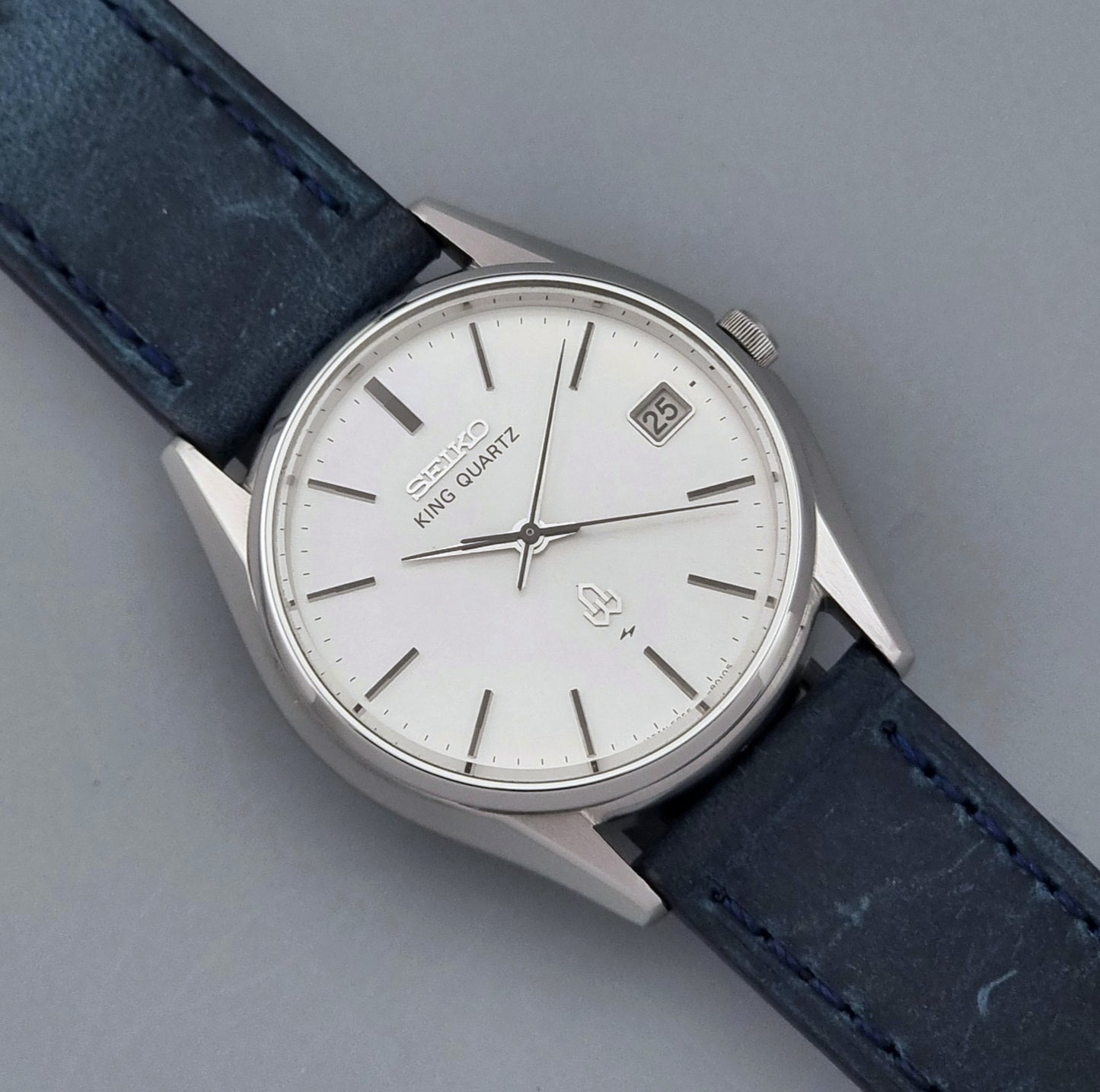 Vintage Seiko King Quartz watch 5855-8010 with blue leather strap on a gray background close up dial view