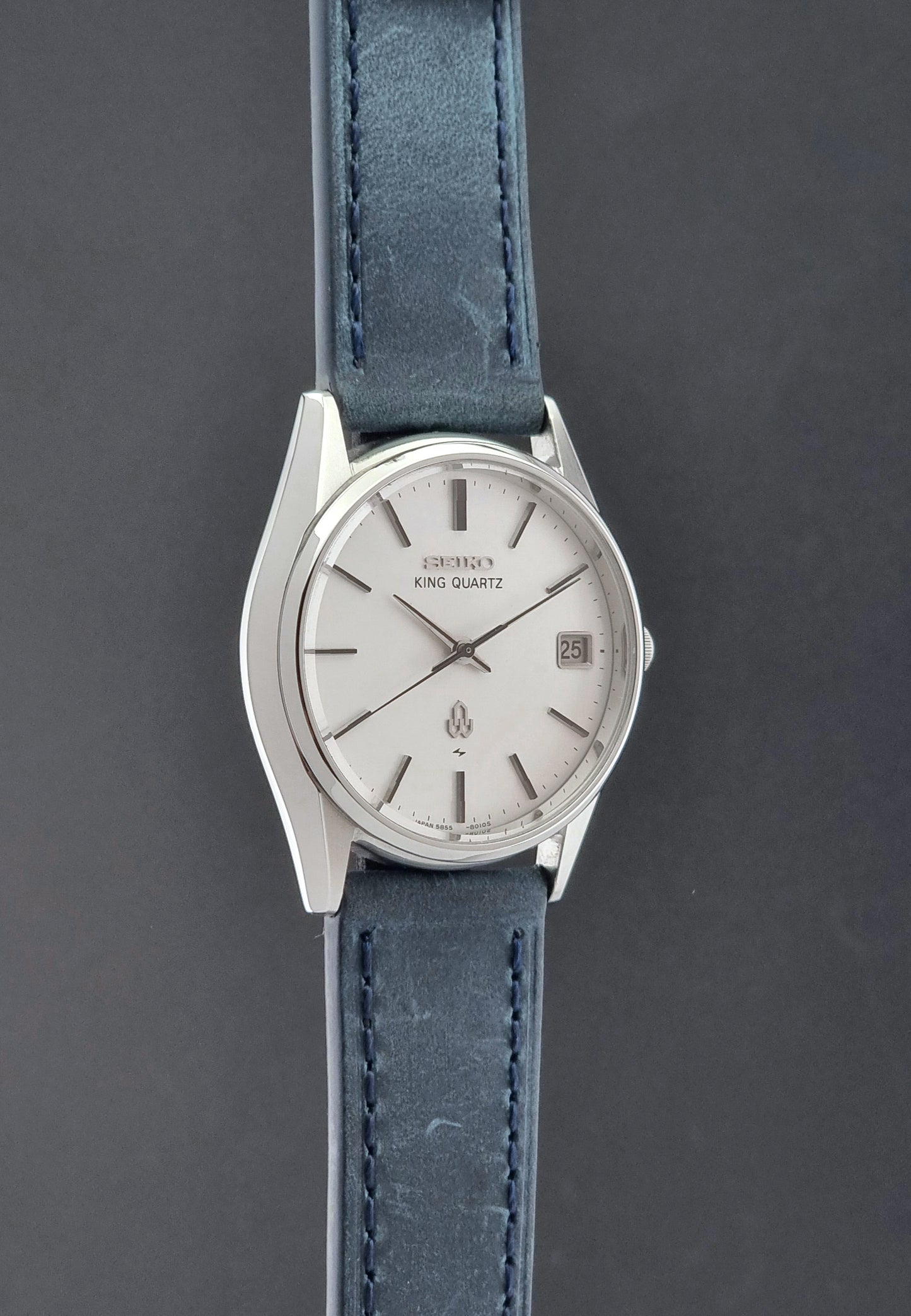 Vintage Seiko King Quartz watch 5855-8010 with blue leather strap on a gray background side profile view