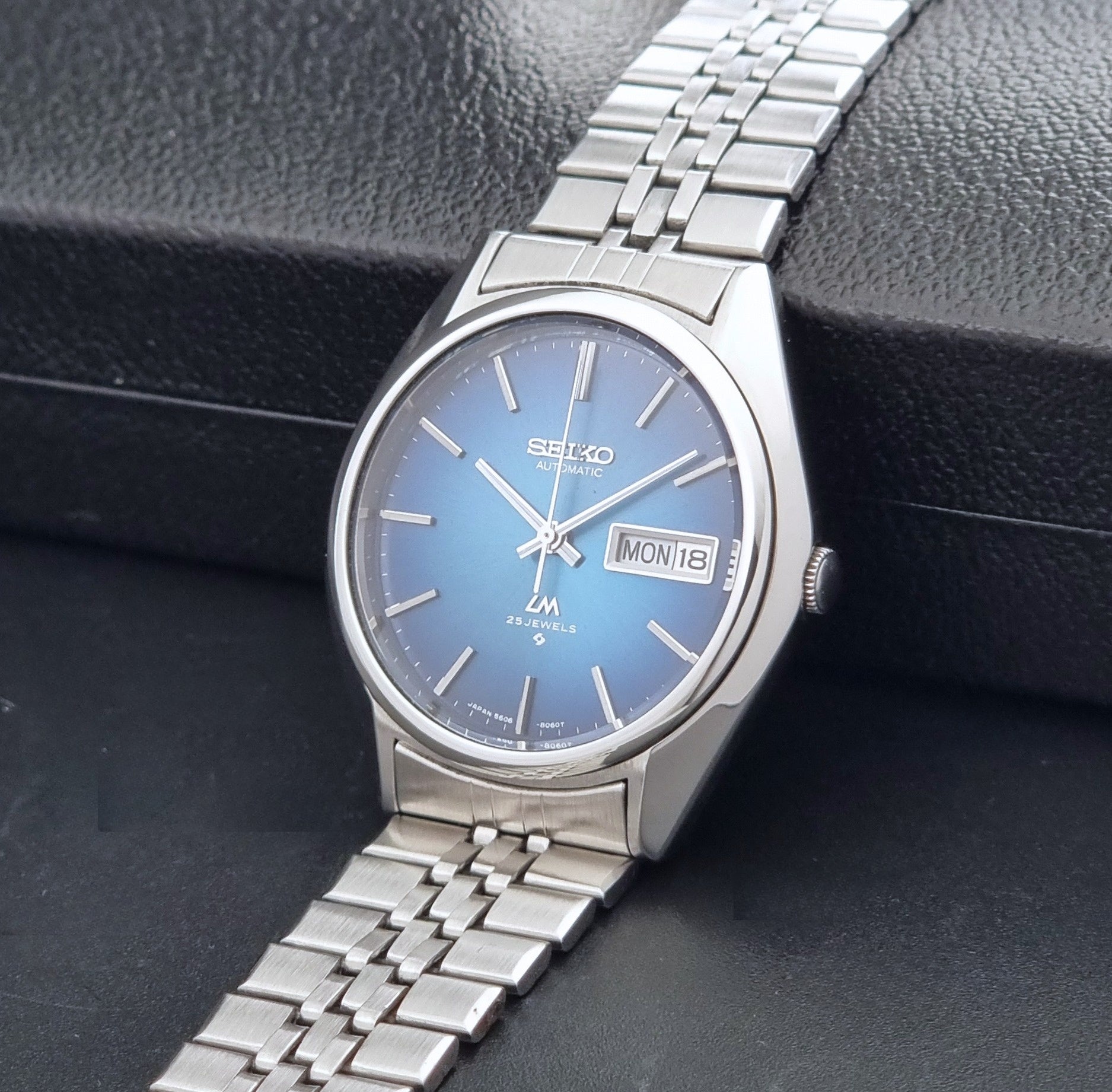 Vintage Seiko LordMatic 5606-8030 Wristwatch with blue dial on dark background crown view
