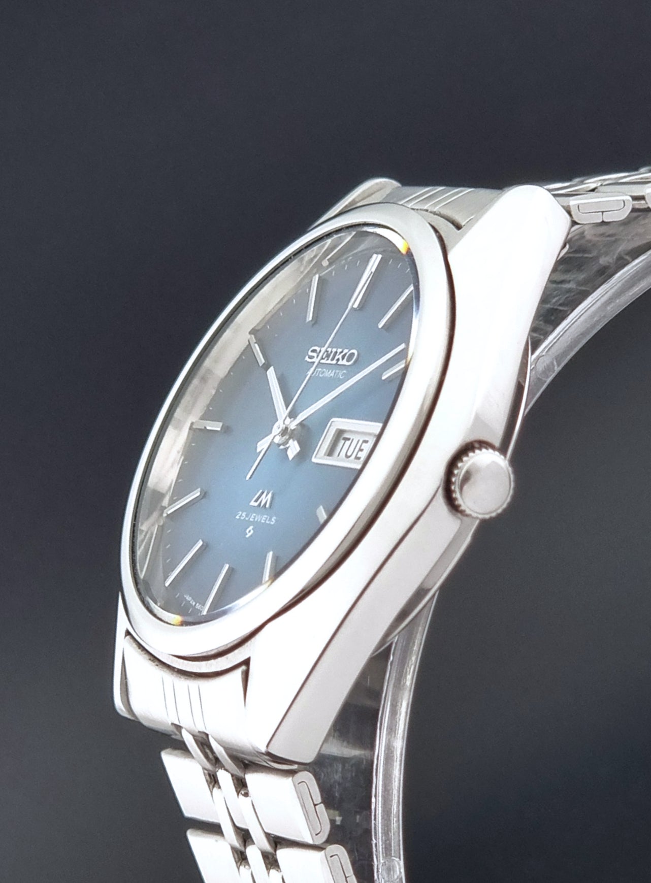 Vintage Seiko LordMatic 5606-8030 Wristwatch with blue dial on dark background crown profile view