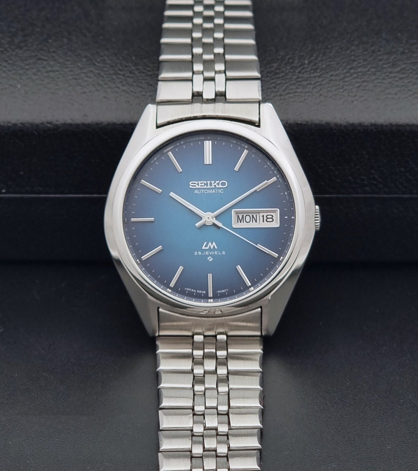 Vintage Seiko LordMatic 5606-8030 Wristwatch with blue dial on dark background dial view