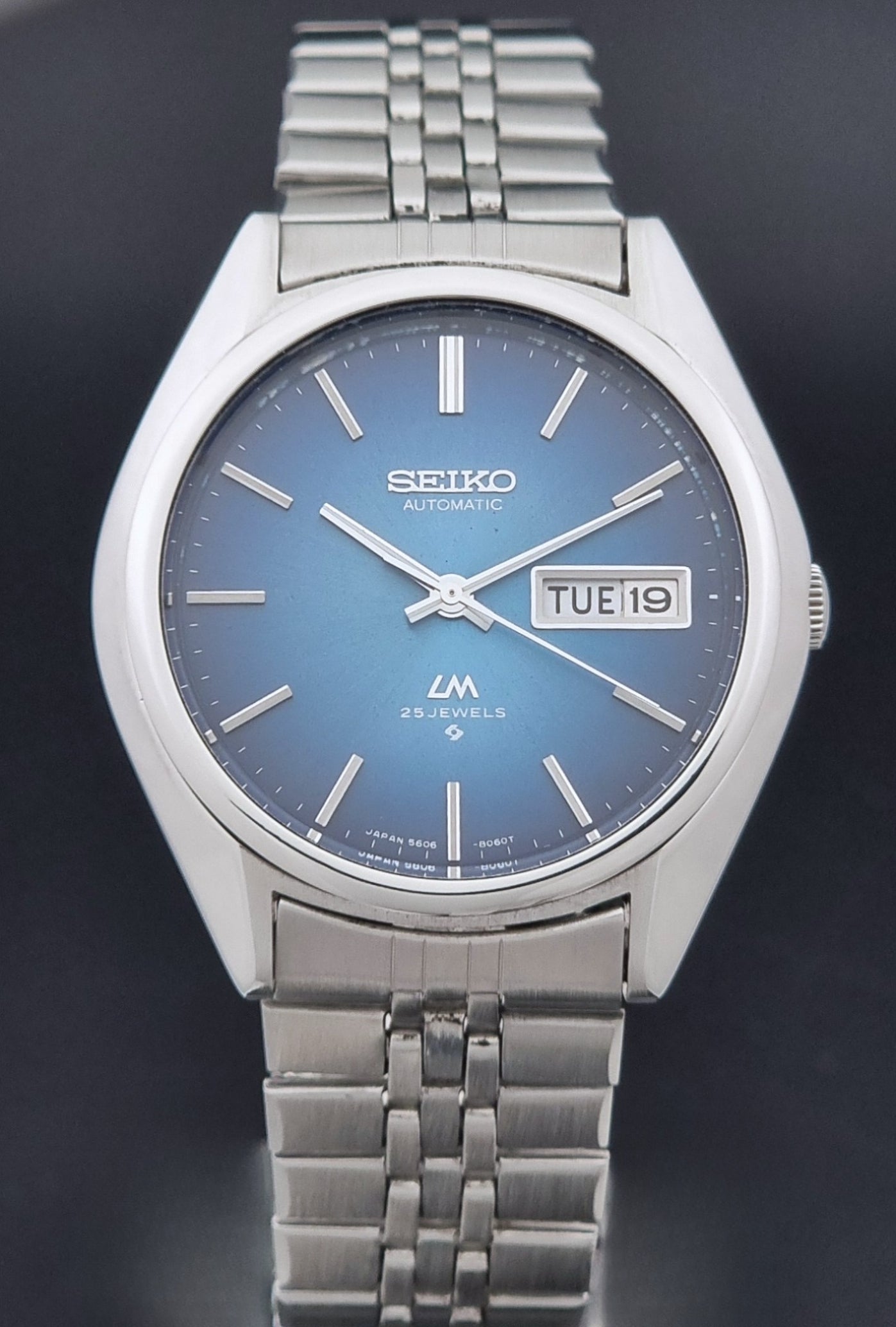 Vintage Seiko LordMatic 5606-8030 Wristwatch with blue dial on dark background close dial view