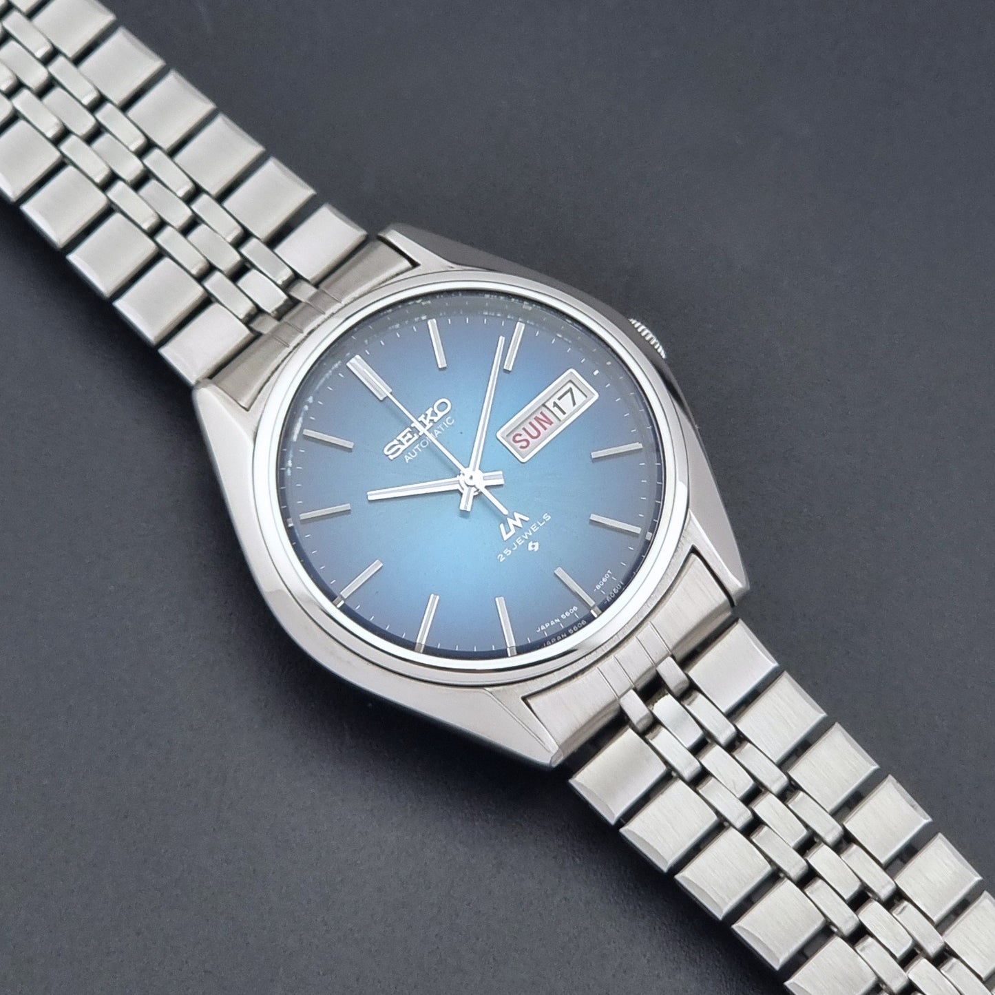Vintage Seiko LordMatic 5606-8030 Wristwatch with blue dial on dark background close up dial view