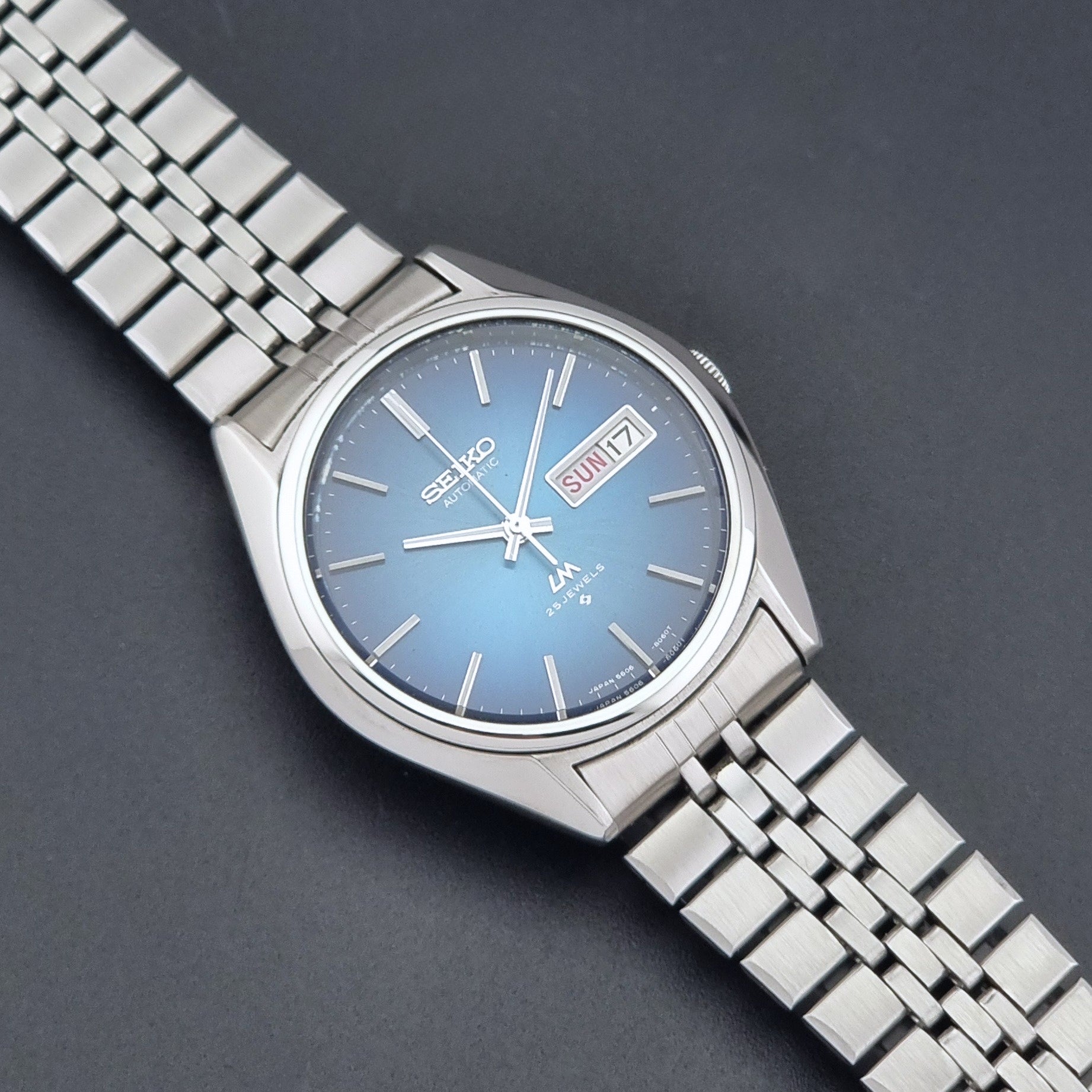 Vintage Seiko LordMatic 5606-8030 Wristwatch with blue dial on dark background close up dial view