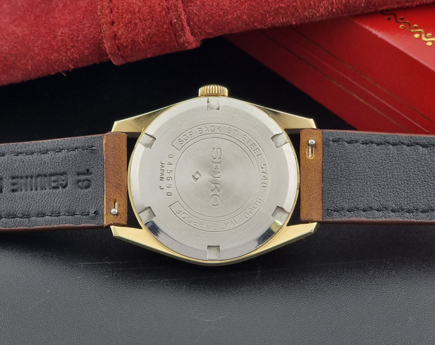 Vintage Seiko watch Lord Marvel 5740-8000 with brown leather strap and gold case on a dark background case back view