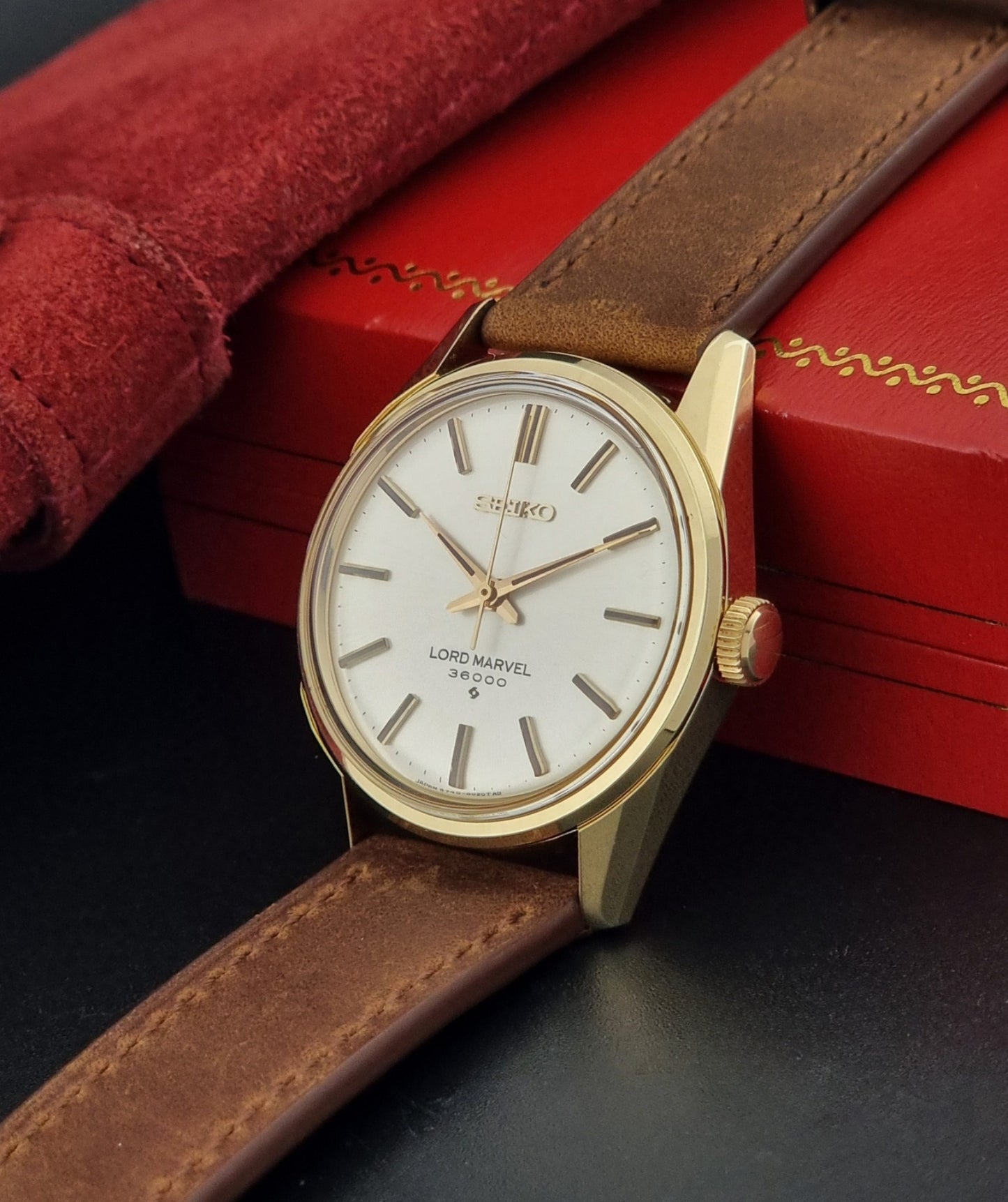 Vintage Seiko watch Lord Marvel 5740-8000 with brown leather strap and gold case on a dark background crown view