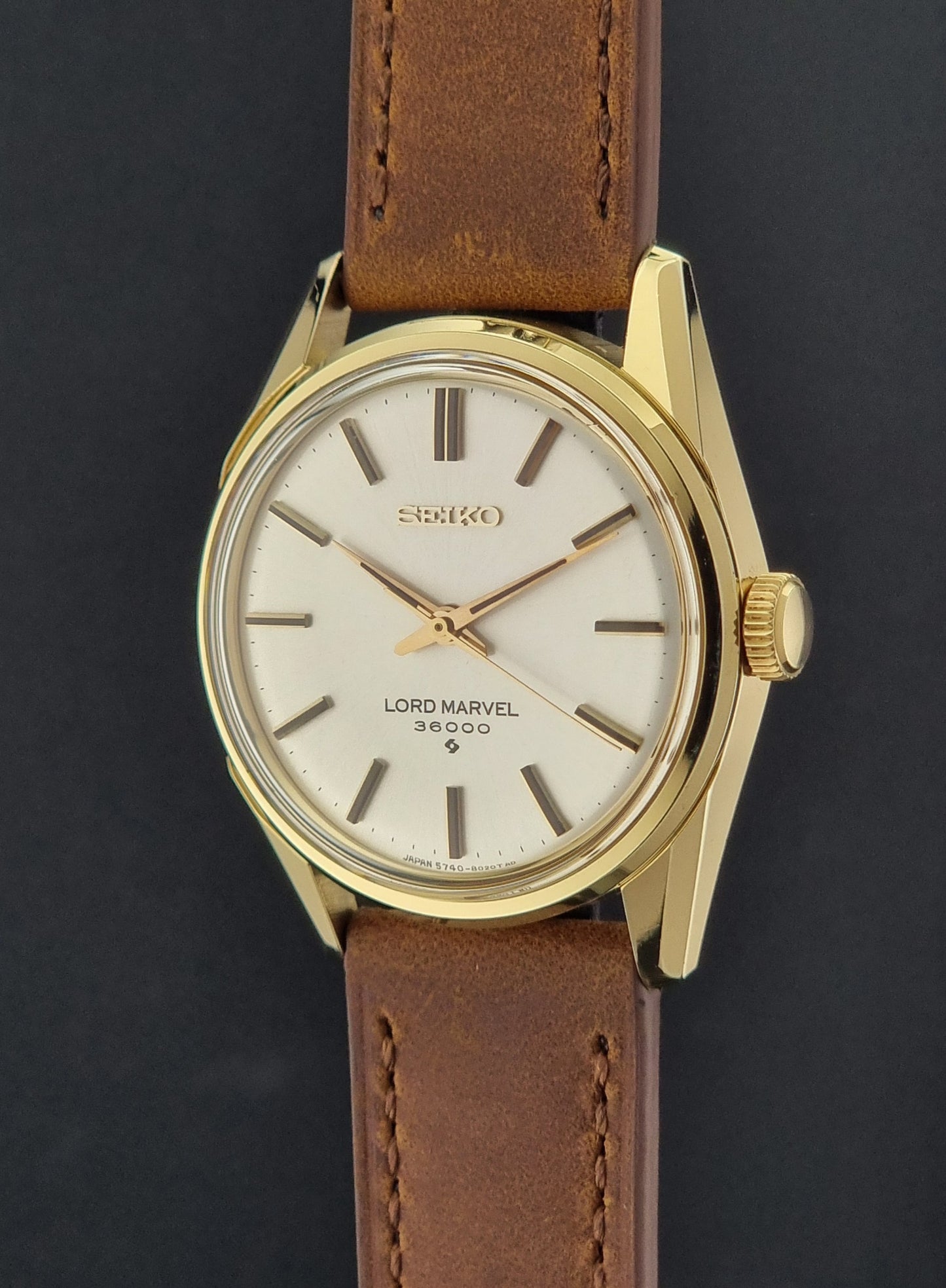 Vintage Seiko watch Lord Marvel 5740-8000 with brown leather strap and gold case on a dark background crown profile view