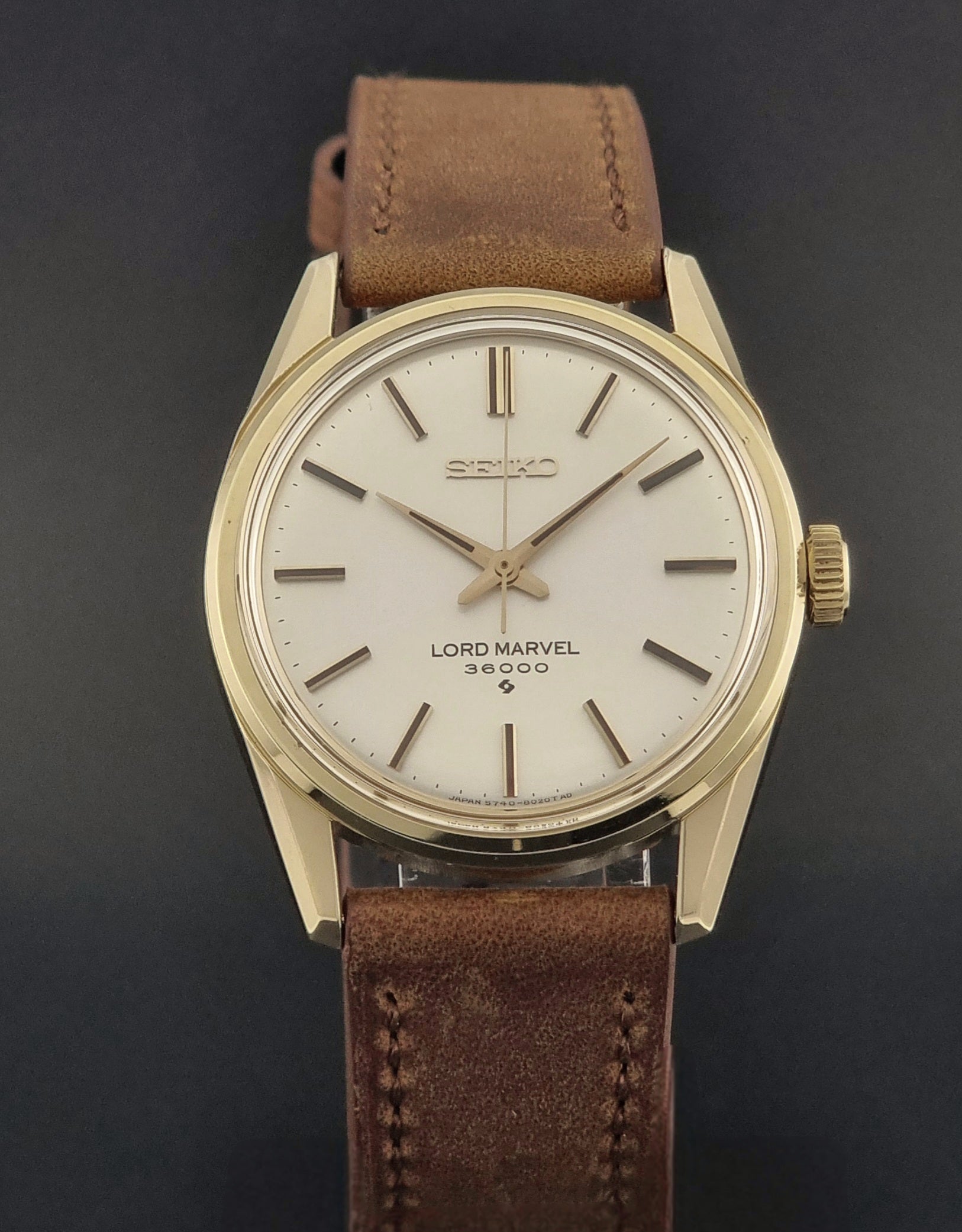 Vintage Seiko watch Lord Marvel 5740-8000 with brown leather strap and gold case on a dark background close front view