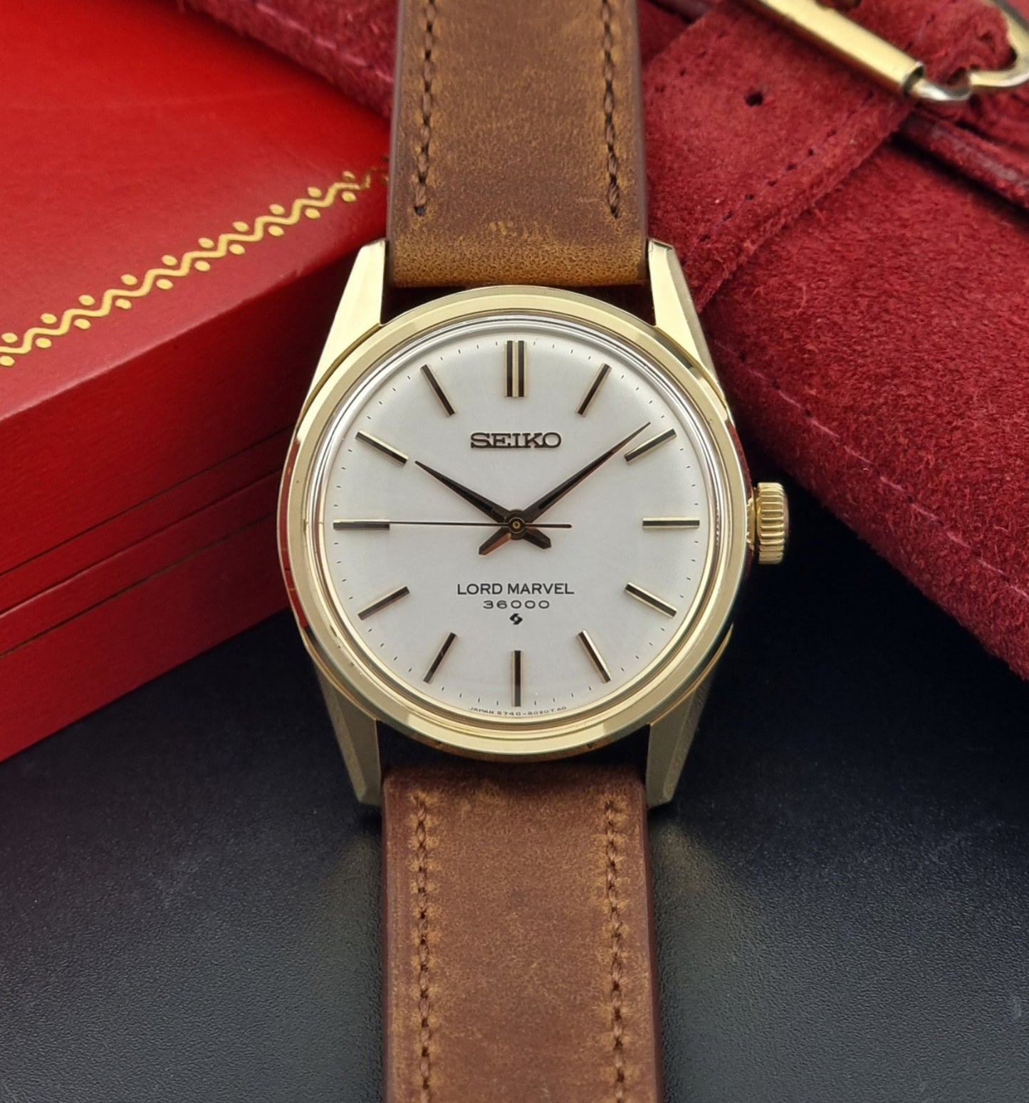 Vintage Seiko watch Lord Marvel 5740-8000 with brown leather strap and gold case on a dark background front view