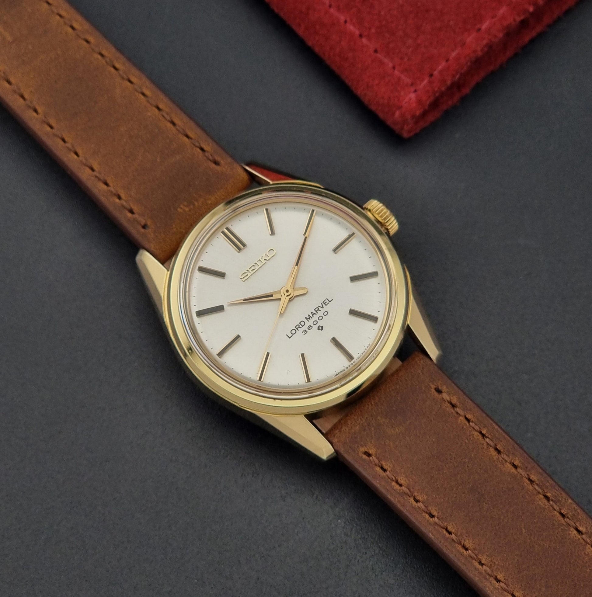 Vintage Seiko watch Lord Marvel 5740-8000 with brown leather strap and gold case on a dark background