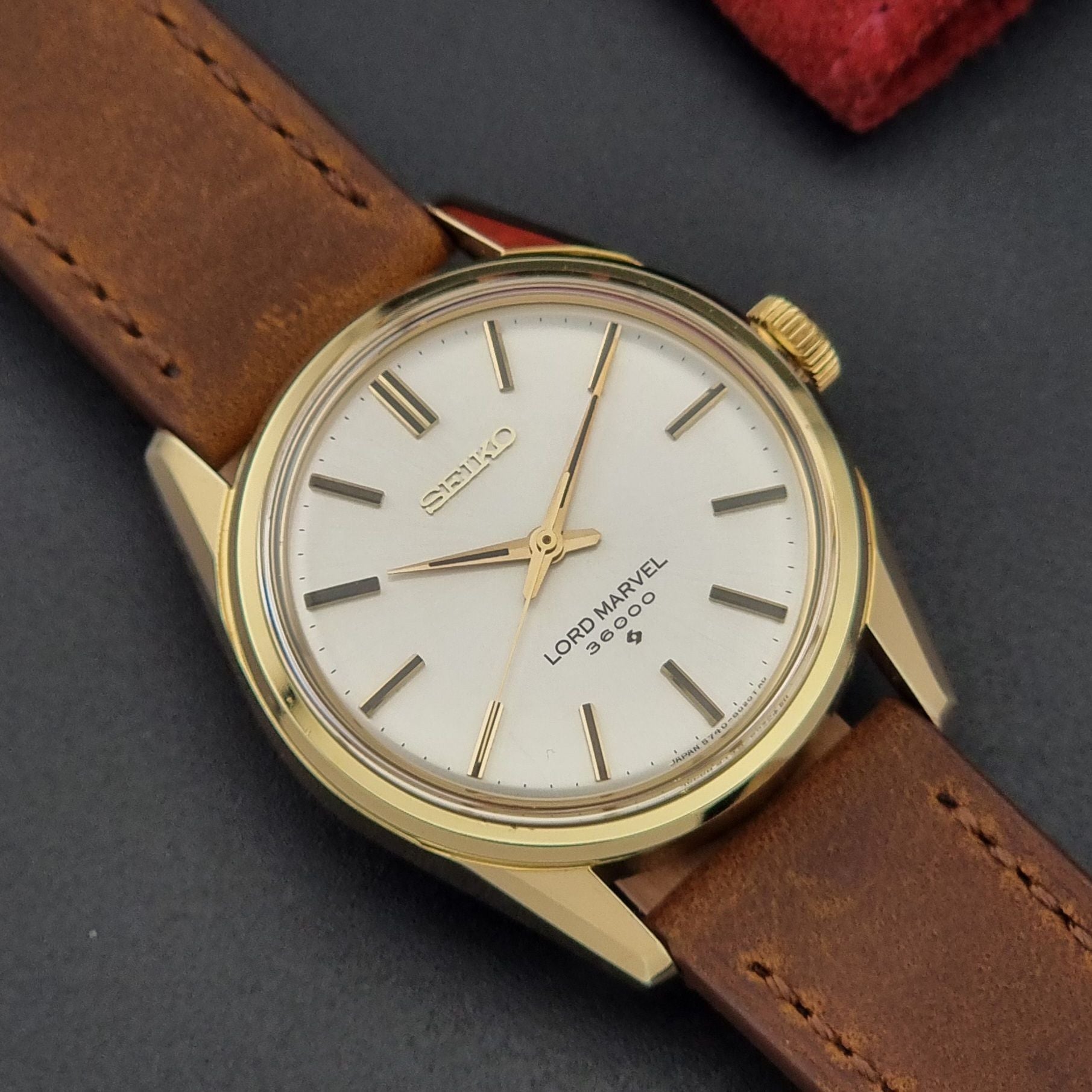 Vintage Seiko watch Lord Marvel 5740-8000 with brown leather strap and gold case on a dark background dial view