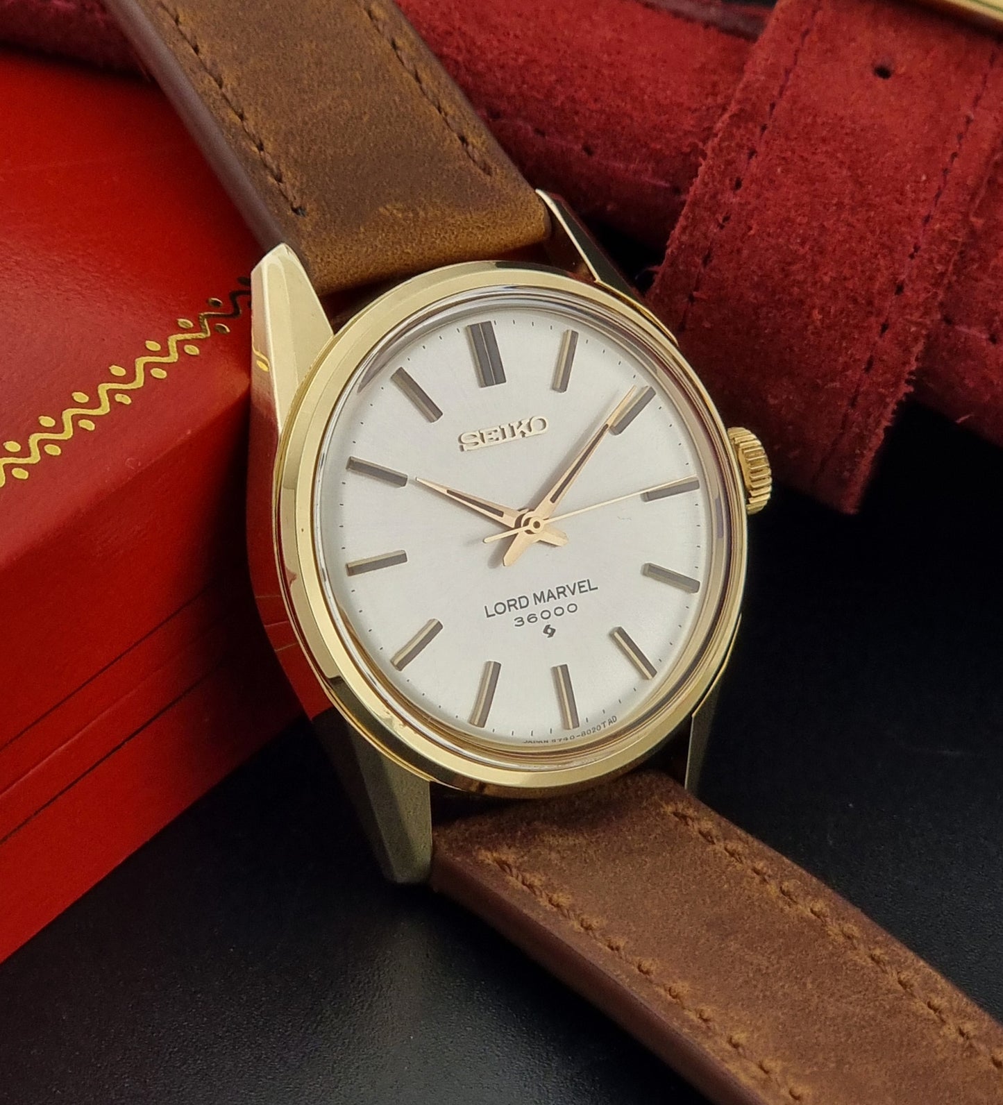 Vintage Seiko watch Lord Marvel 5740-8000 with brown leather strap and gold case on a dark background side view