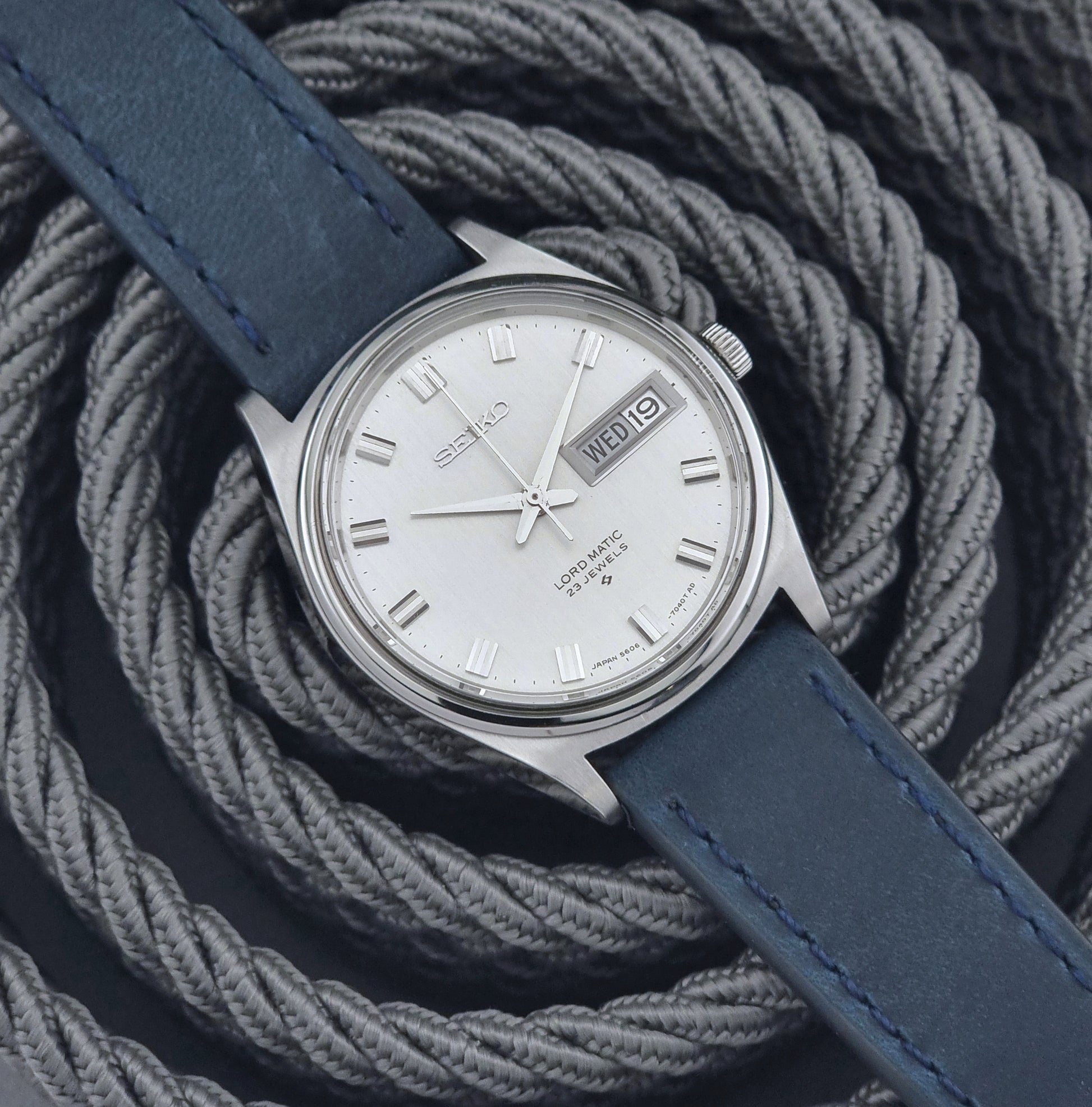 Vintage Seiko watch with blue strap on a textured gray background