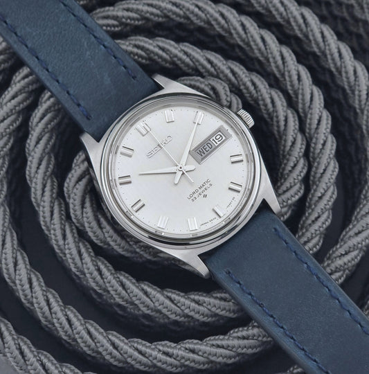 Vintage Seiko watch with blue strap on a textured gray background