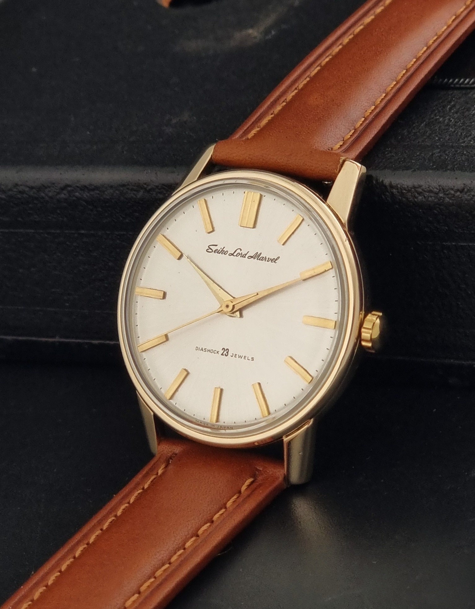 Vintage Seiko Lordmarvel Wristwatch 5740-1990 with a gold filled case and brown leather strap on a dark background crown view