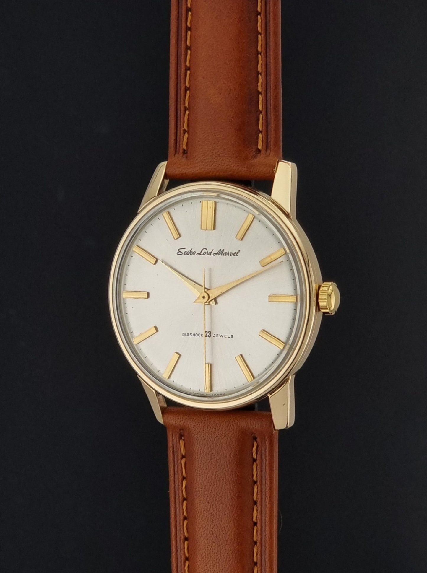 Vintage Seiko Lordmarvel Wristwatch 5740-1990 with a gold filled case and brown leather strap on a dark background crown profle view