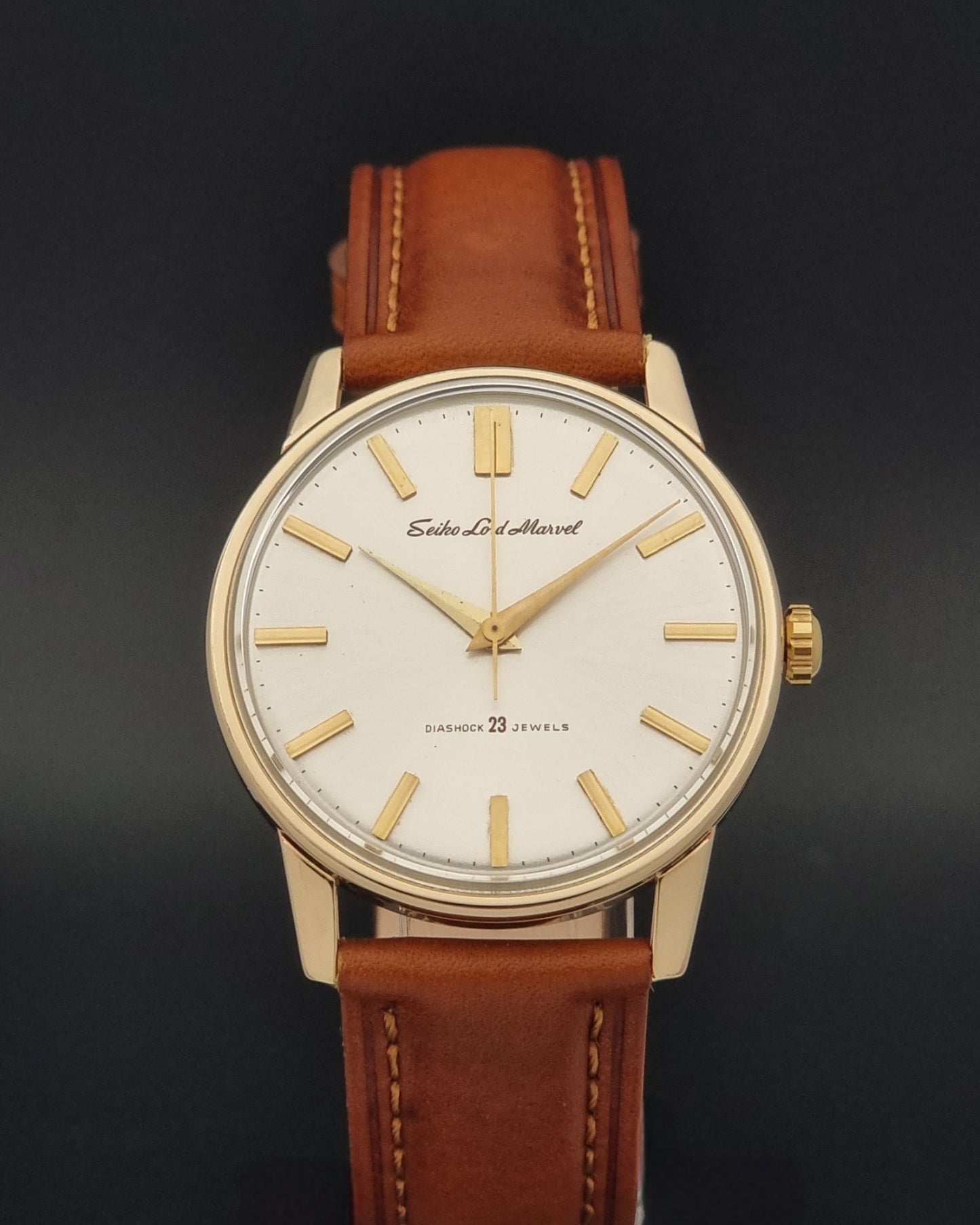 Vintage Seiko Lordmarvel Wristwatch 5740-1990 with a gold filled case and brown leather strap on a dark background close front view