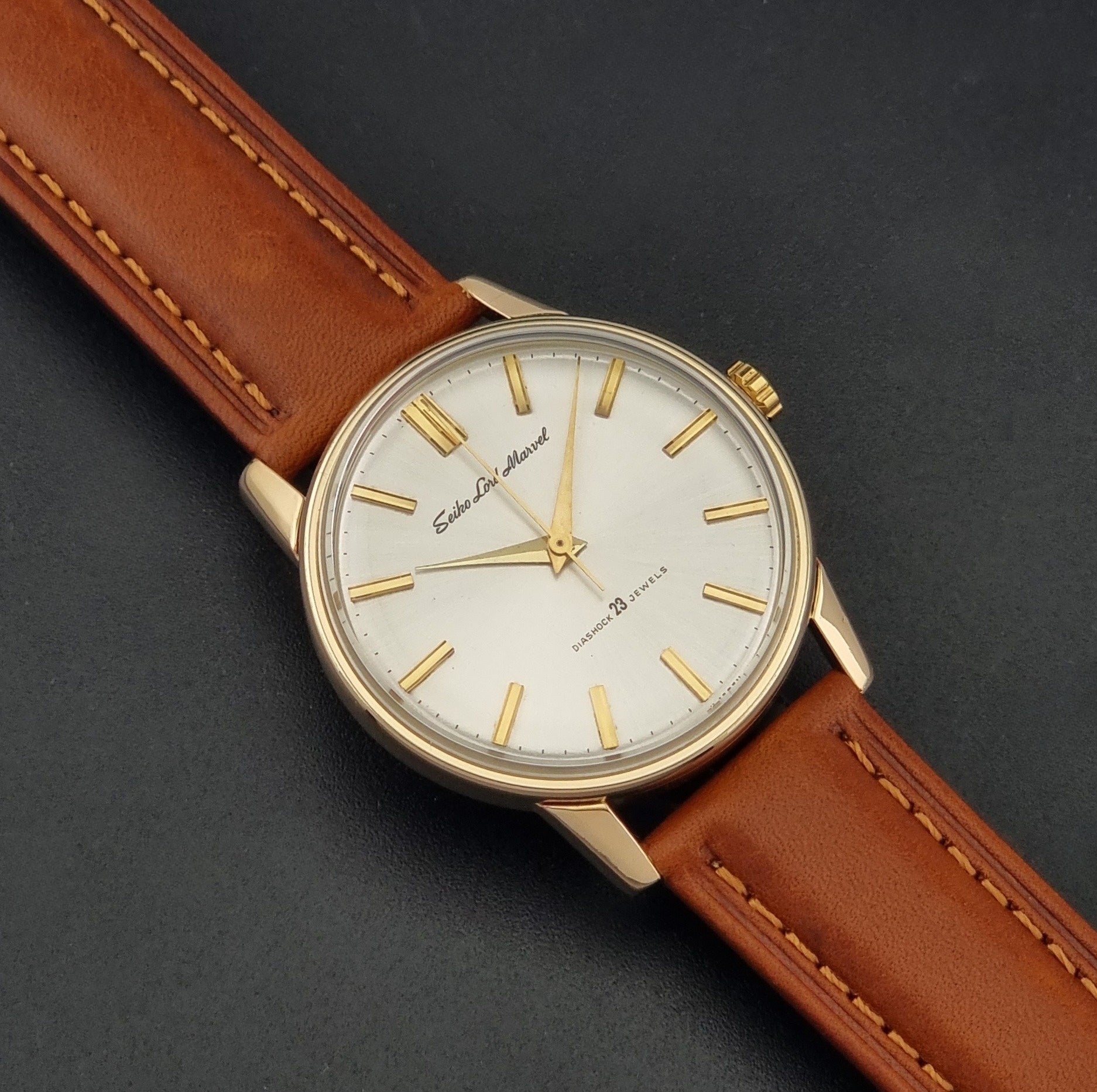 Vintage Seiko Lordmarvel Wristwatch 5740-1990 with a gold filled case and brown leather strap on a dark background close up dial view
