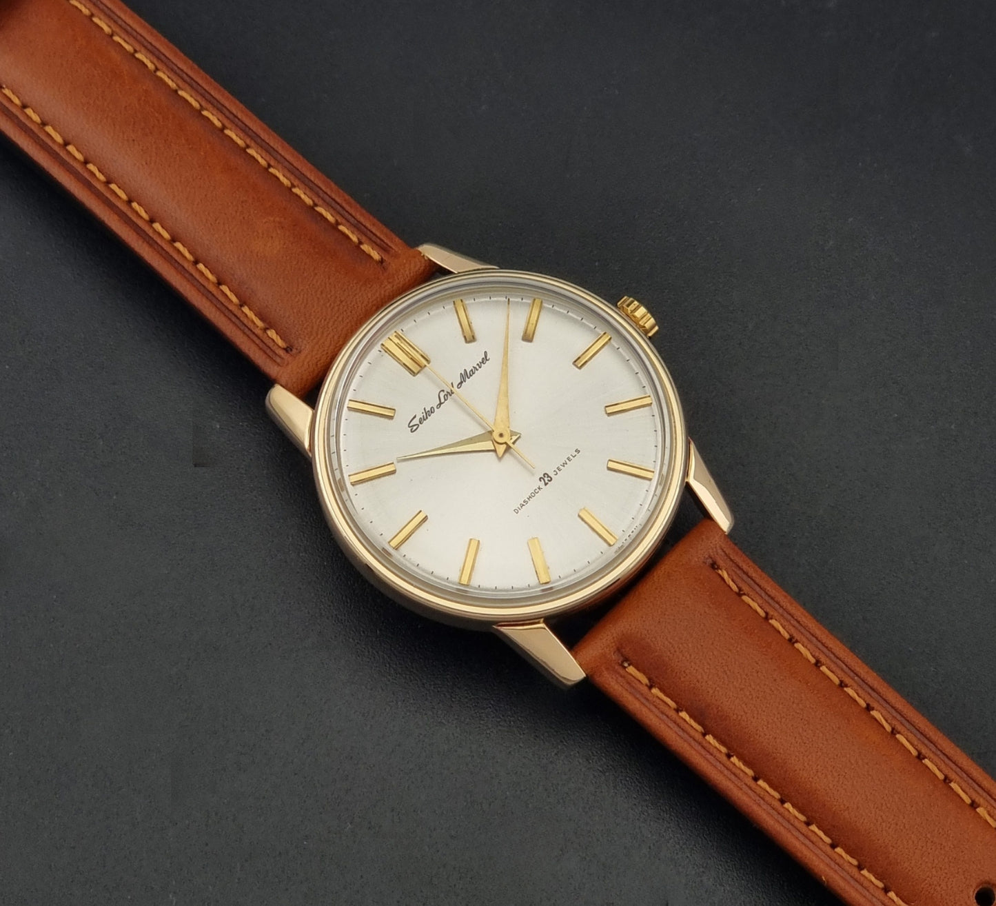 Vintage Seiko Lordmarvel Wristwatch 5740-1990 with a gold filled case and brown leather strap on a dark background dial