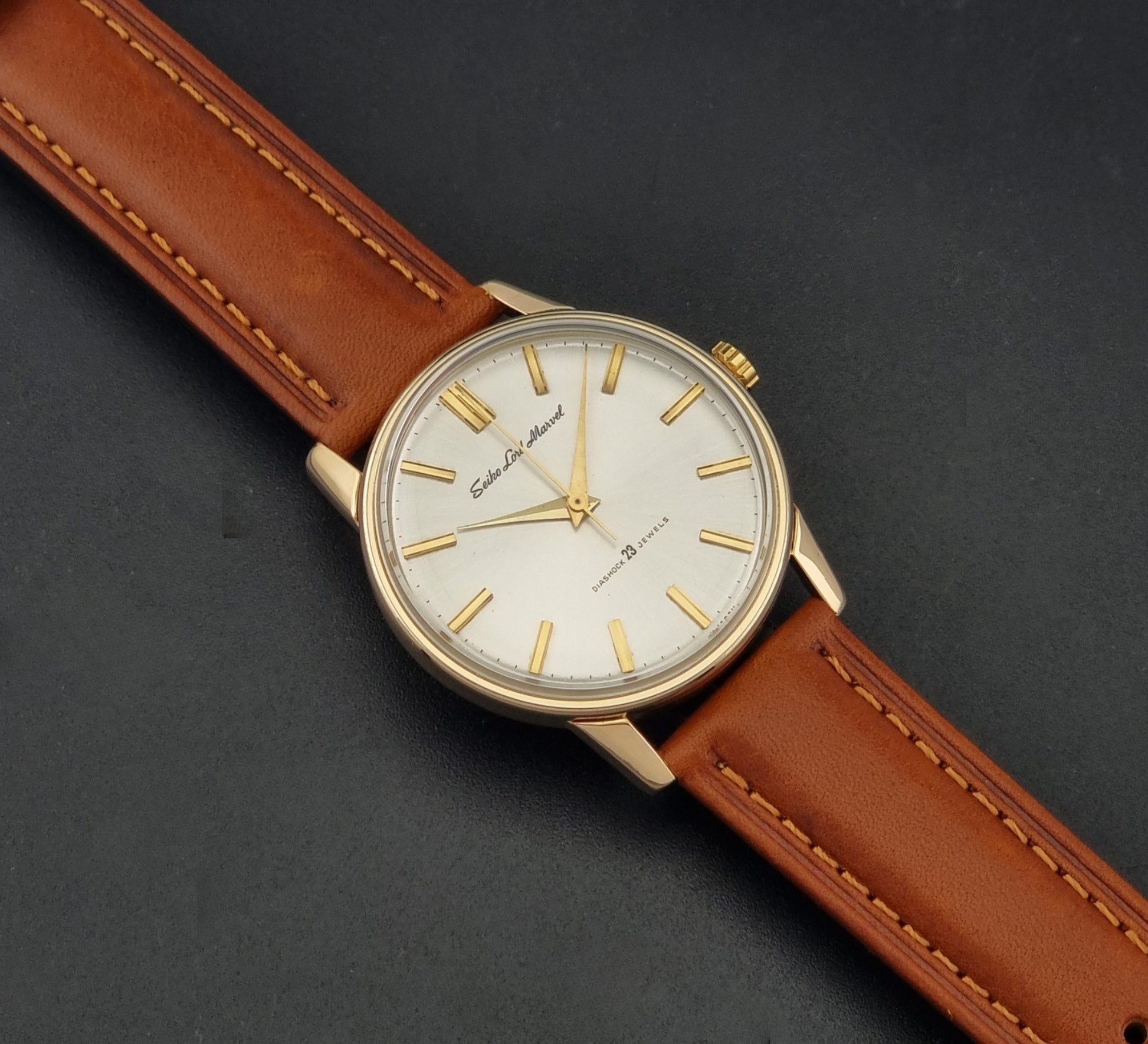 Vintage Seiko Lordmarvel Wristwatch 5740-1990 with a gold filled case and brown leather strap on a dark background dial