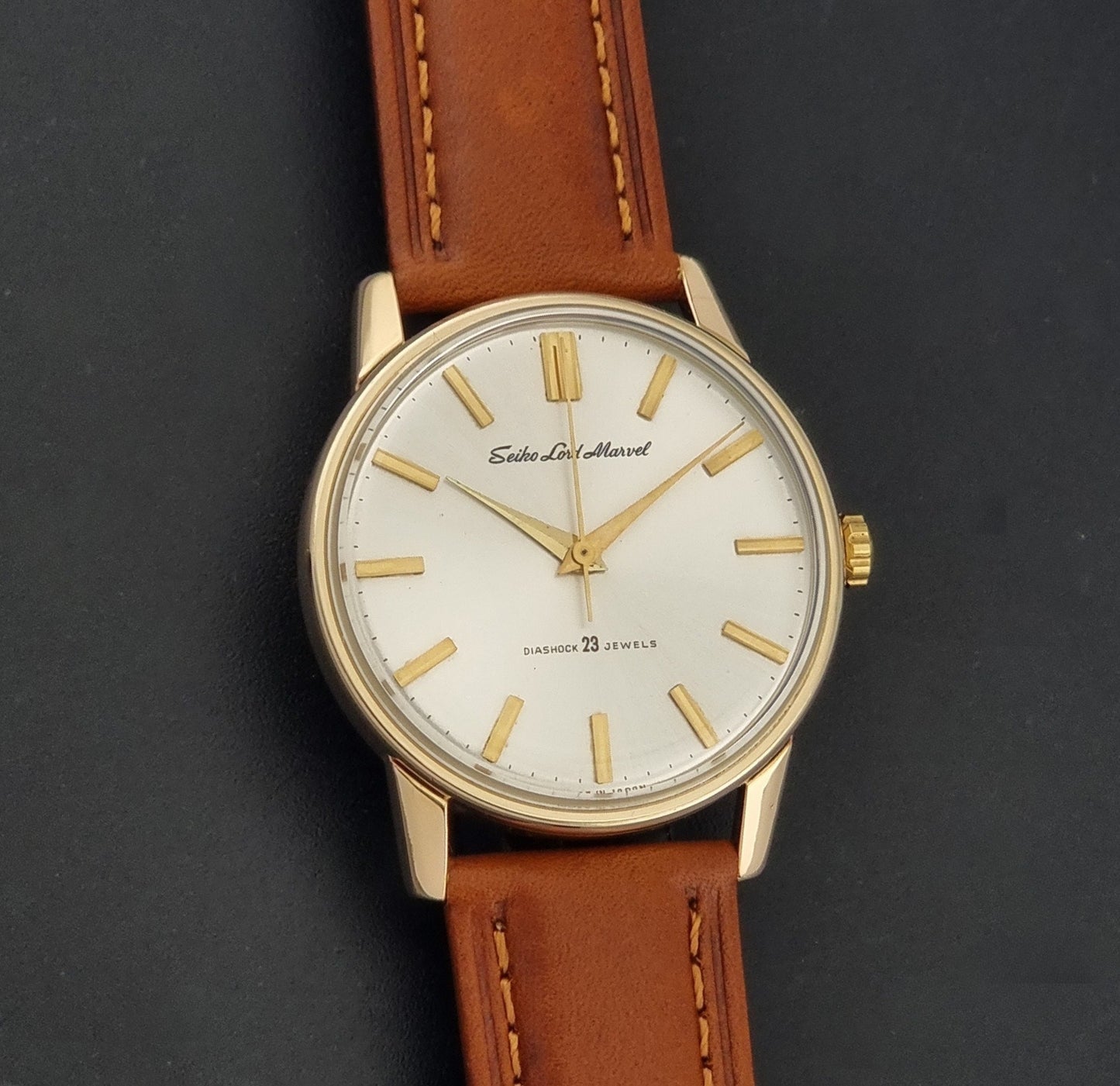 Vintage Seiko Lordmarvel Wristwatch 5740-1990 with a gold filled case and brown leather strap on a dark background front view