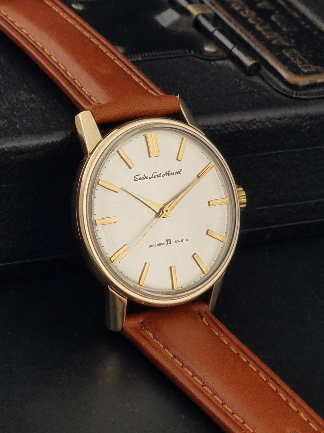 Vintage Seiko Lordmarvel Wristwatch 5740-1990 with a gold filled case and brown leather strap on a dark background side view