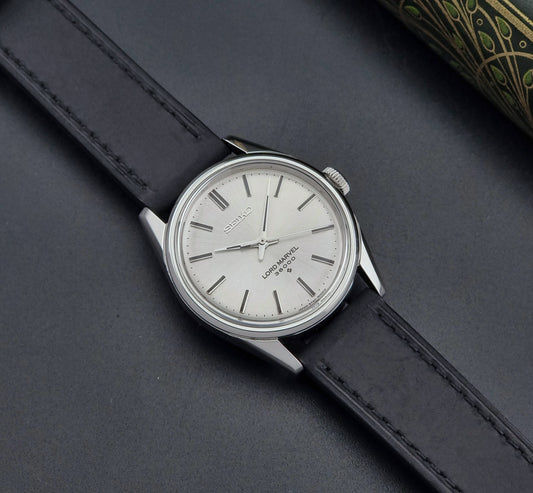 Vintage Seiko watch Lord Marvel 5740-8000 with black leather strap on a dark gray background dial