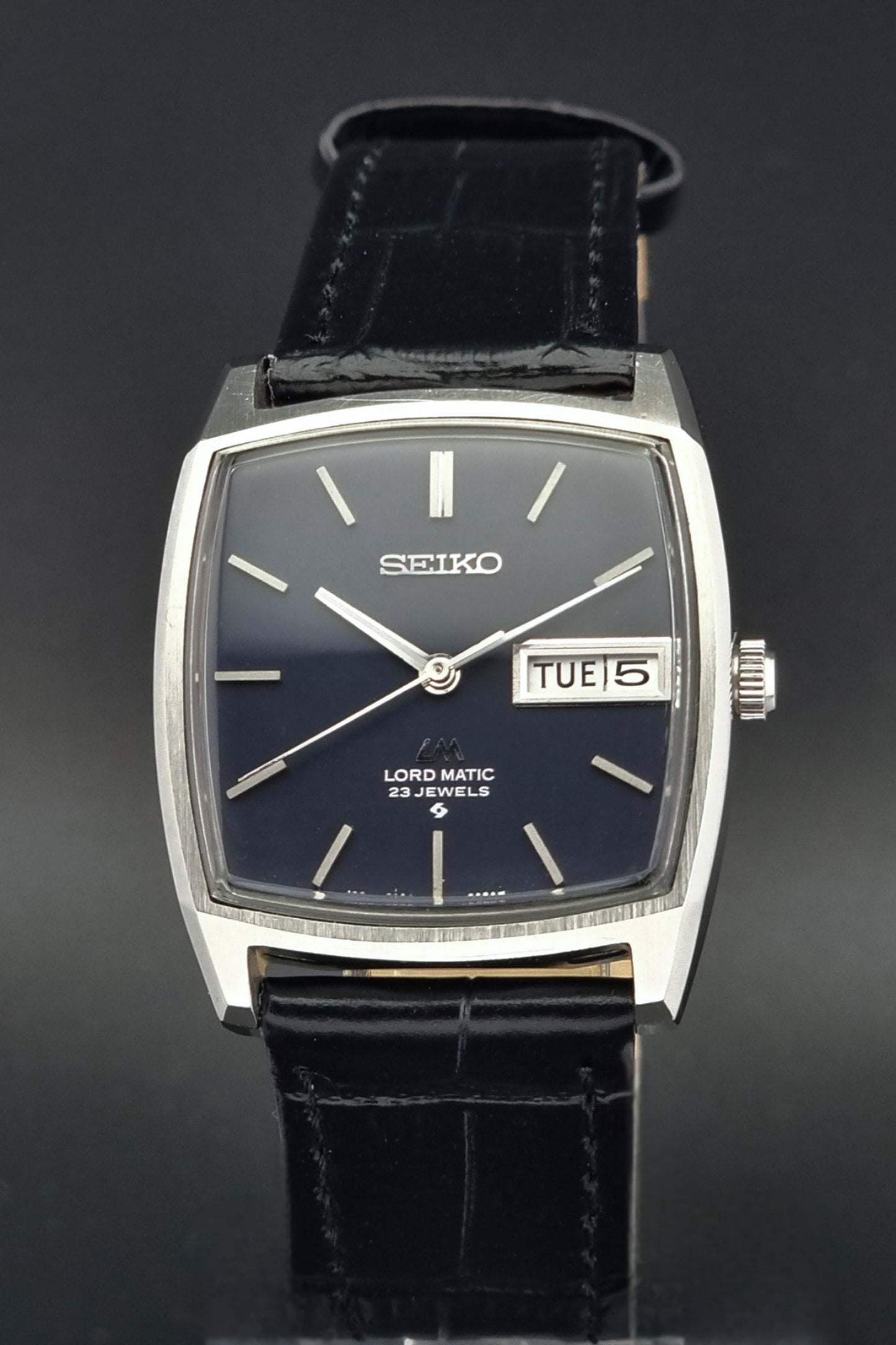 Vintage Seiko Lord Matic watch with black leather strap on a dark background